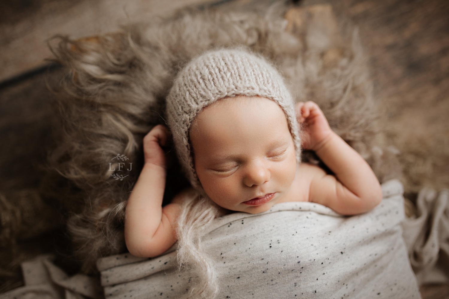 baby tucked in with knitted bonnet hat on rustic style setting