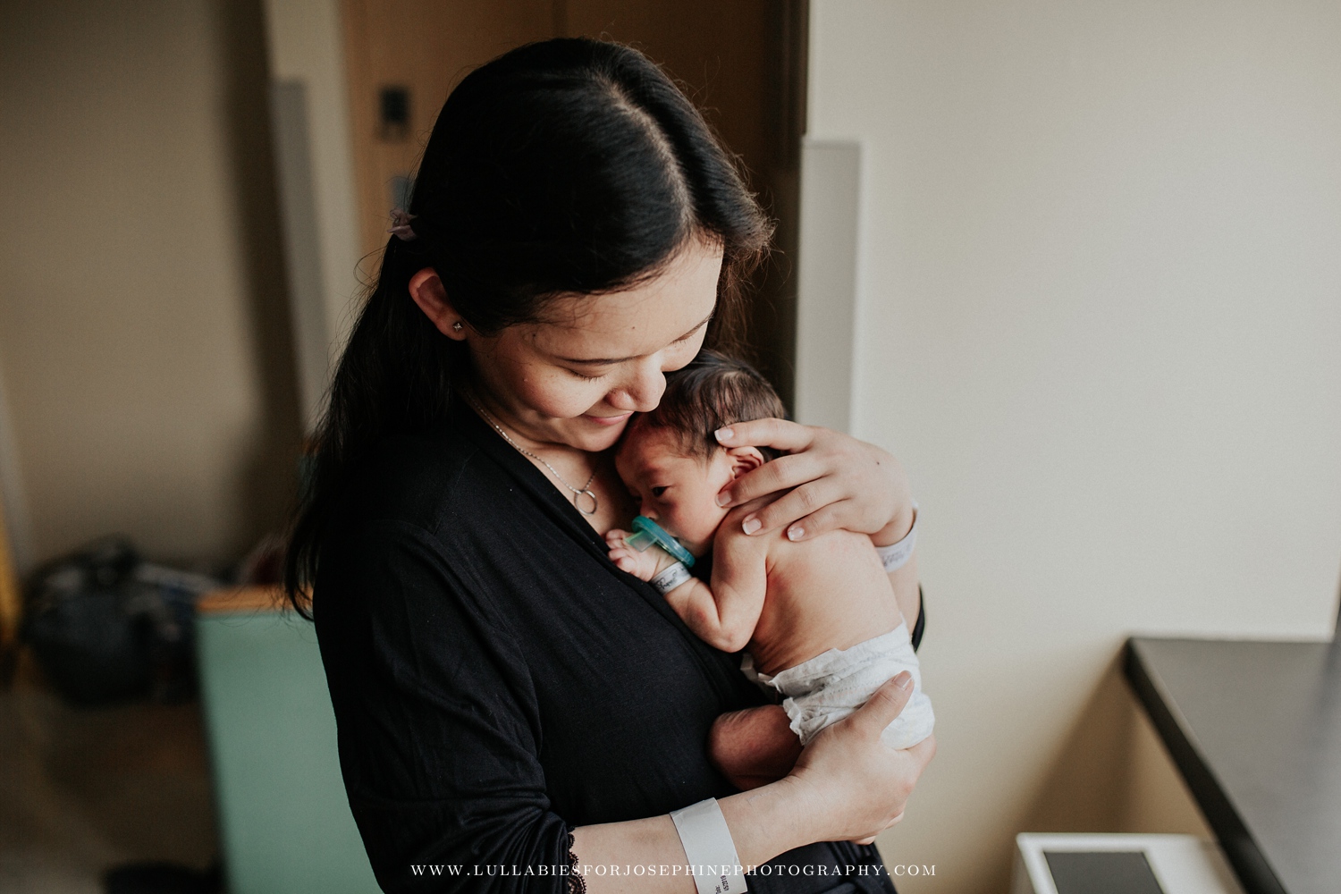 Mom holding newborn boy at his Fresh 48 hospital session in Summit NJ