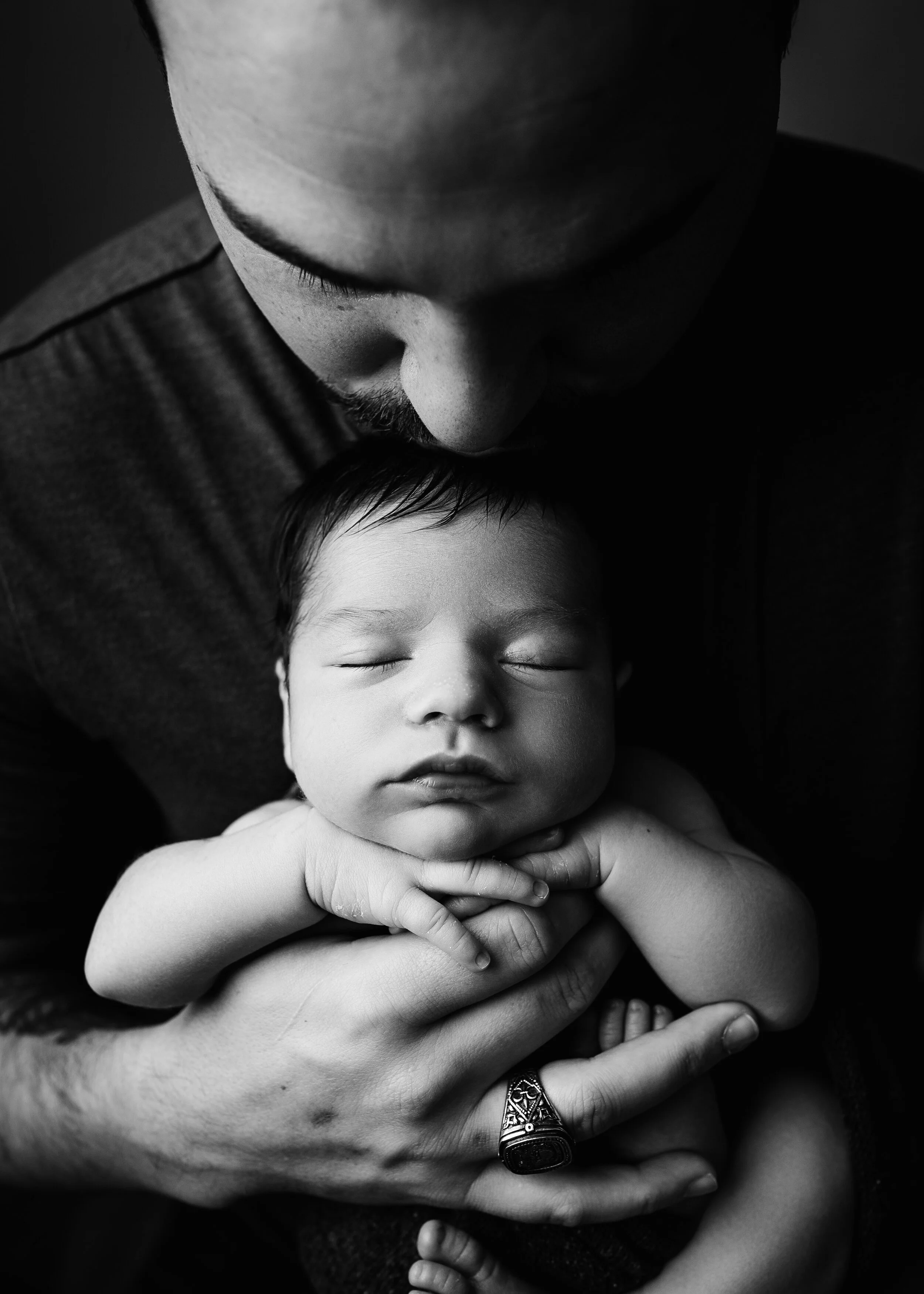 Black and white photo of a man holding a sleeping baby