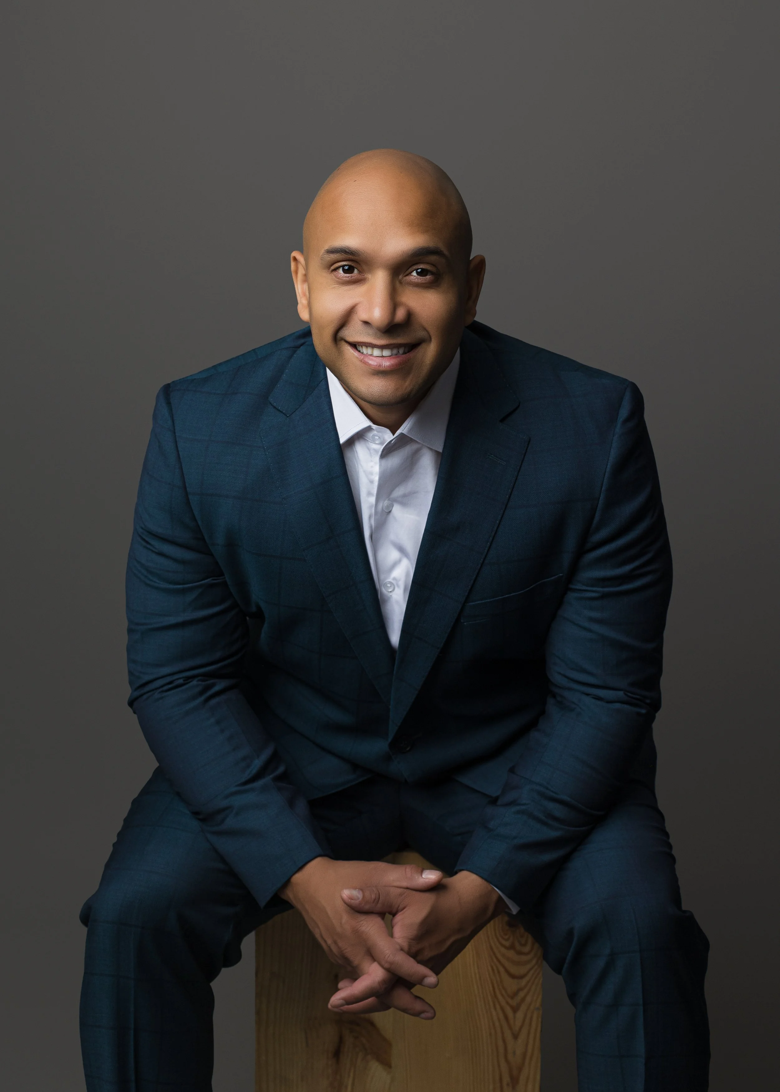 Man wearing a suit posing for a professional headshot photoshoot.