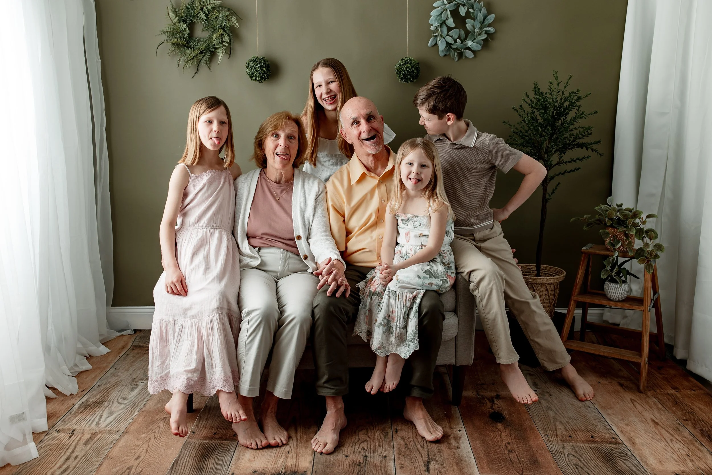 Grandparents and grandchildren making a funny face to the camera having fun with smiles at NJ photography studio.