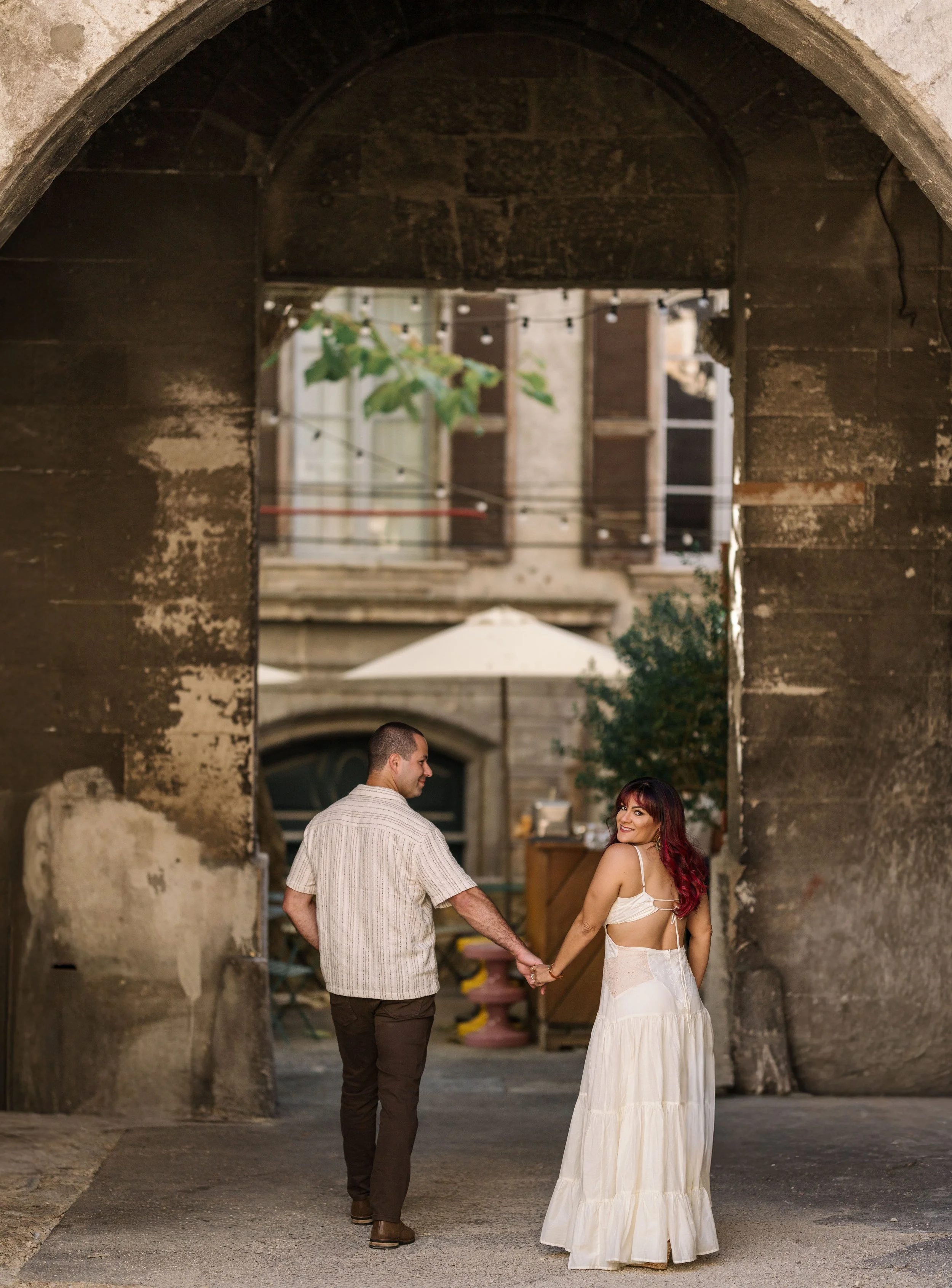 Tamara Gavish and her husband posing for the camera during a couples session dressed in cream in Arles, France