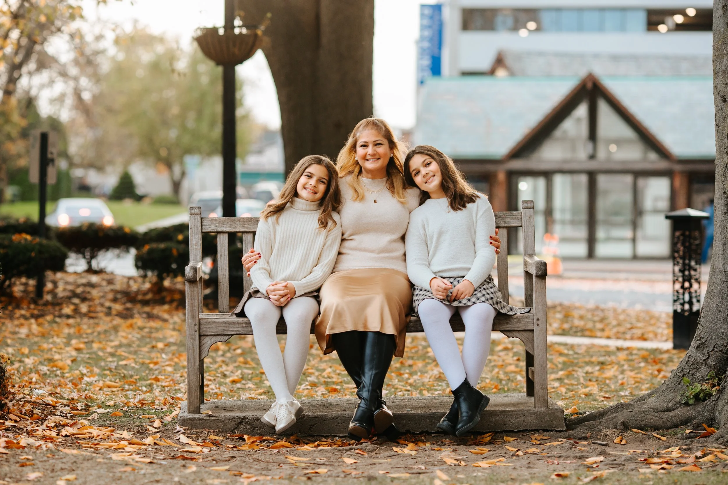 Mom and 2 girls sitting on a bench for family photos in Ridgewood, NJ dountown