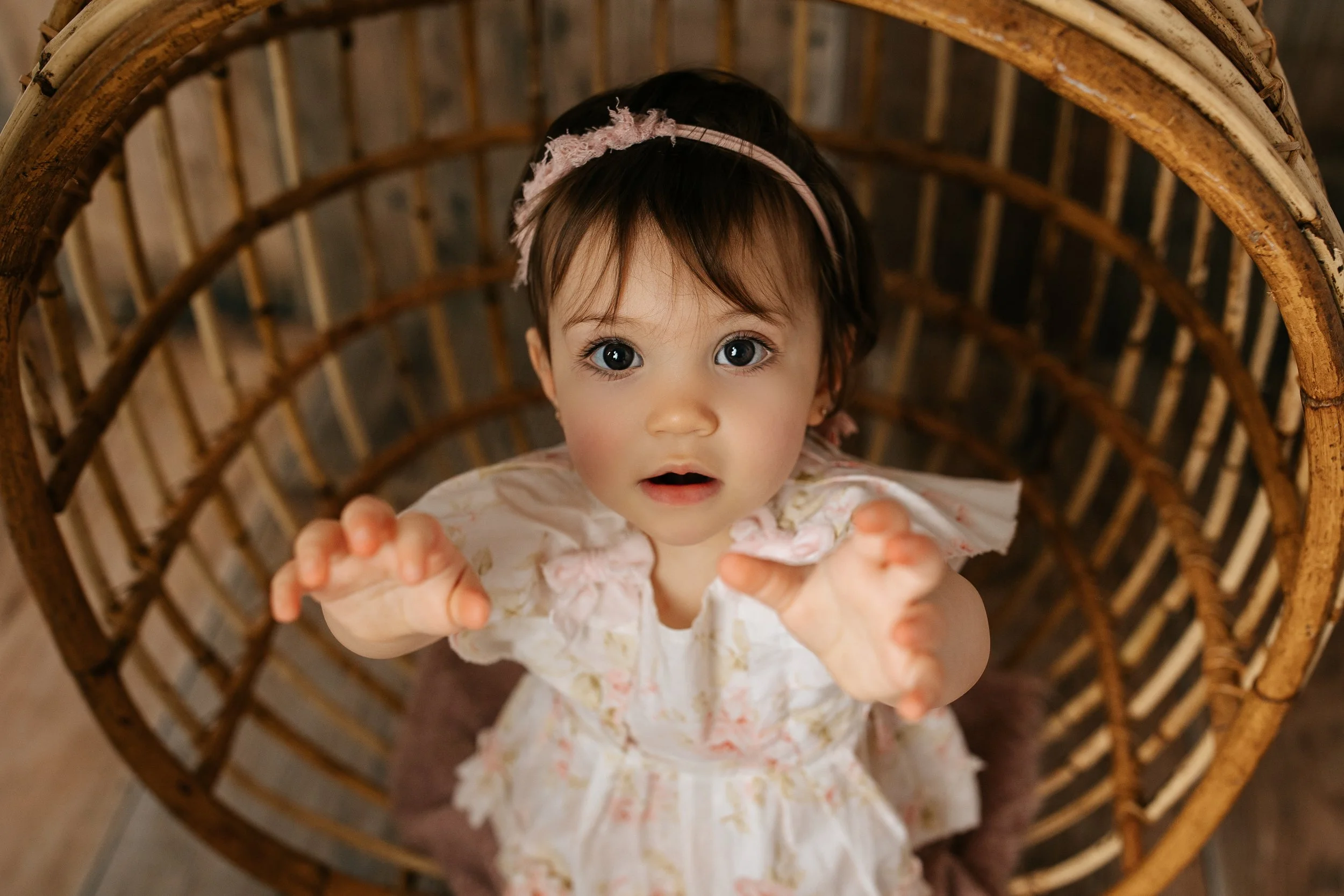 NJ Baby is celebrating her milestone photoshoot looking up with her arms out