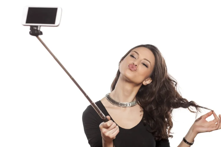 pretty brunette making selfie with a stick
