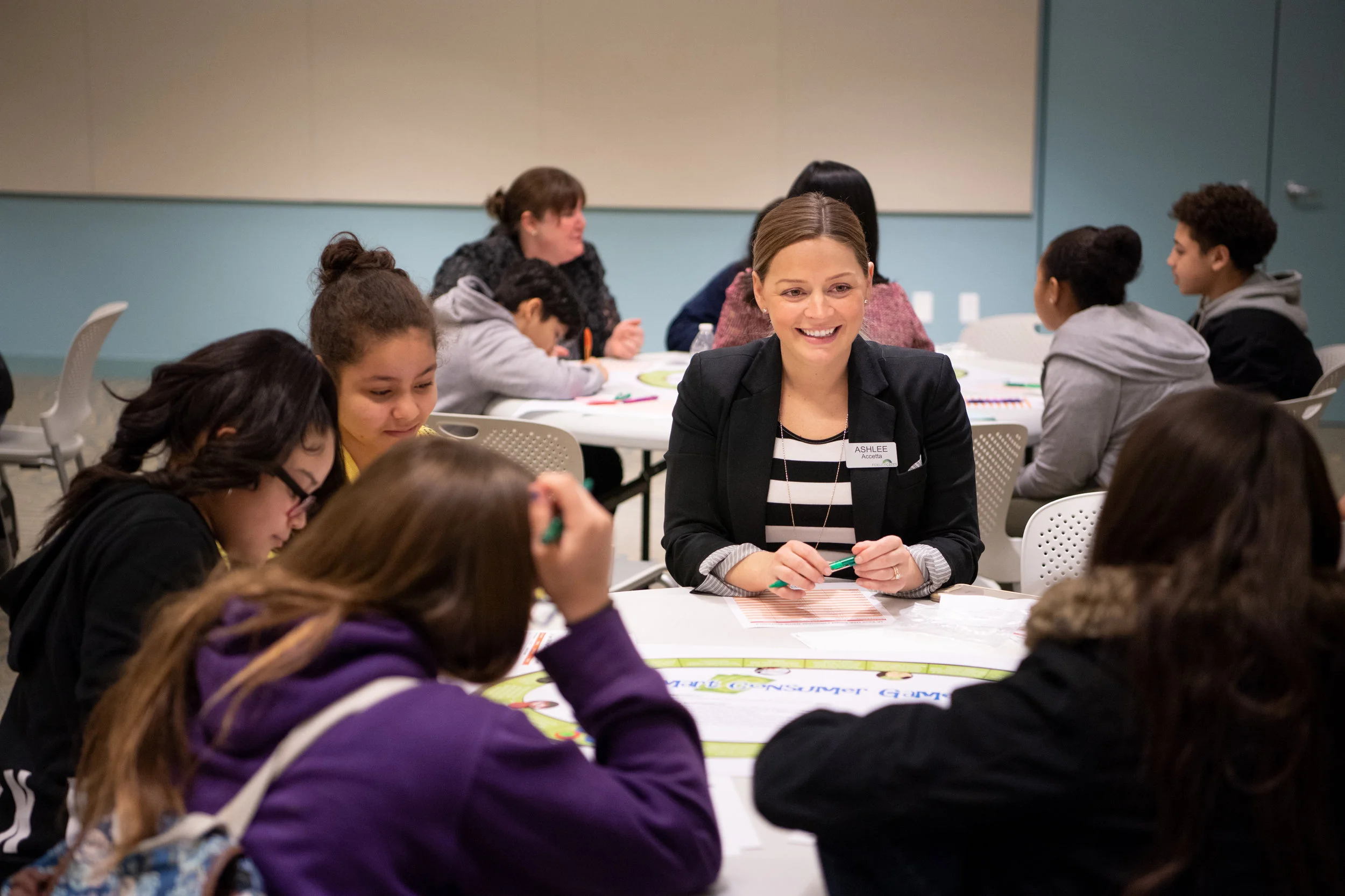 Ashlee Accetta, JA board member and community relations manager at Fidelity Investments, works with Del Sesto Middle School students as part of Congressional Leaders Day during Education Awareness Week.