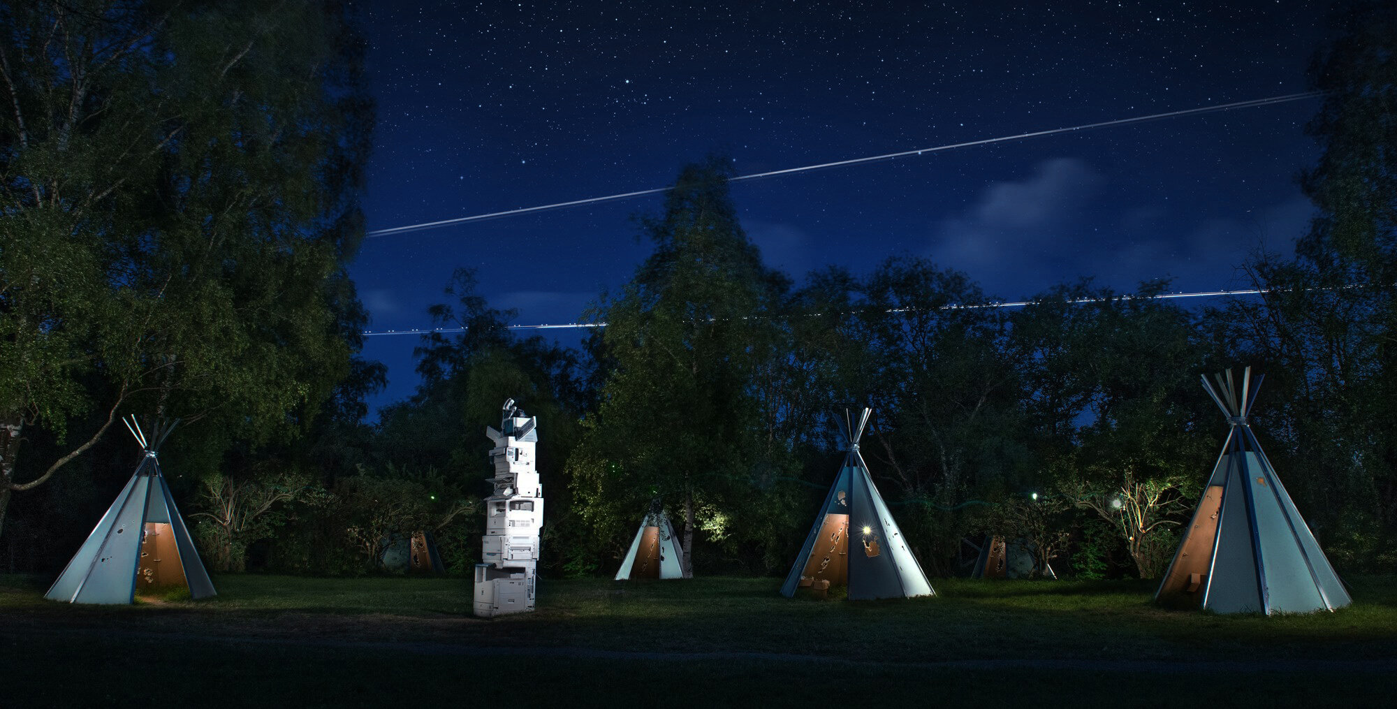5 tipi, made of drywall panels, and тotem pole. Nature as a background. 