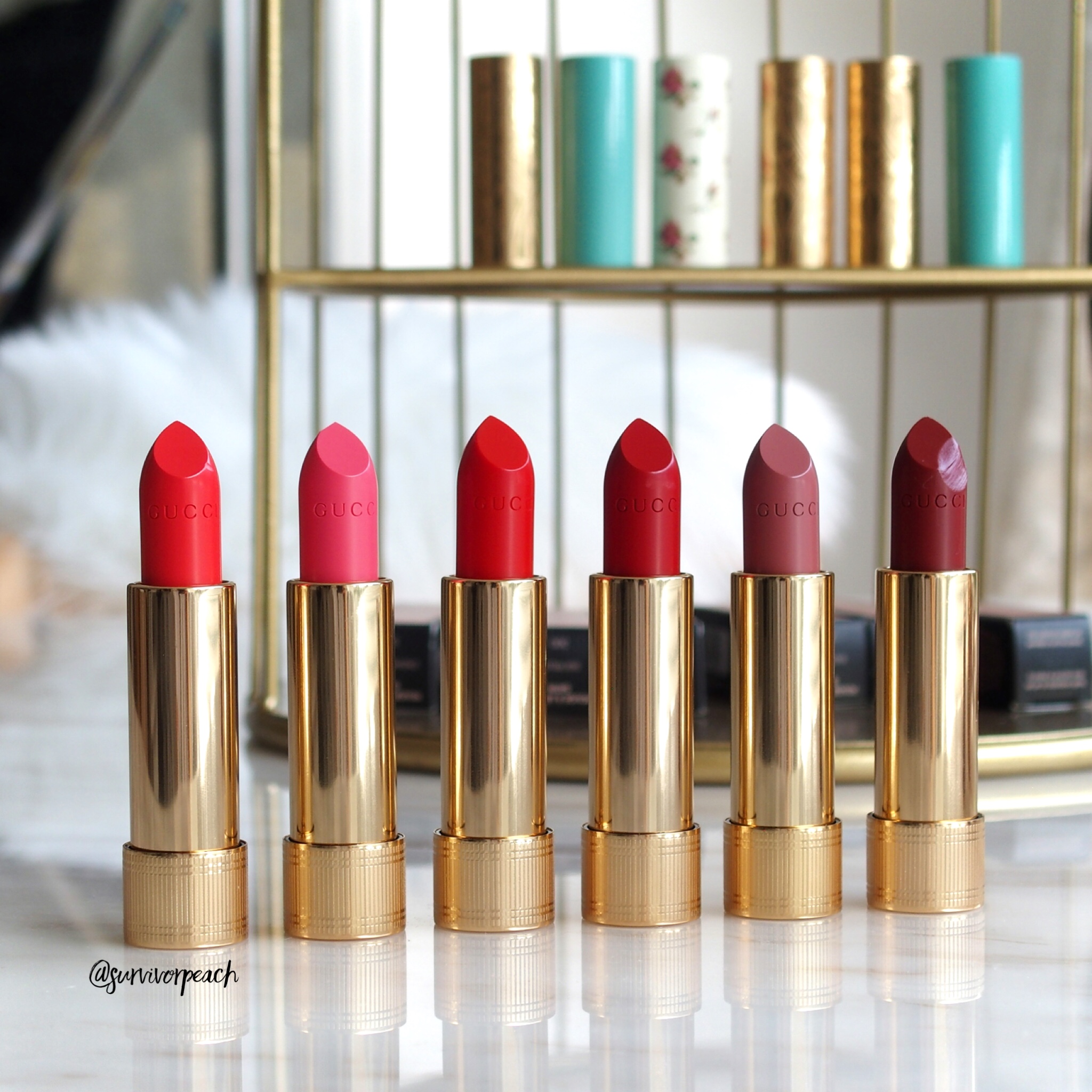 From right: Gucci Baume à Lèvres Lip Balm 4 Penelope Plum, 2 No More Orchids, Rouge à Lèvres Voile Lipstick 302 Agatha Orange, Rouge à Lèvres Satin Lipstick 200 Blaze of Noon, 300 Sadie Firelight, 501 Constance Vermillion