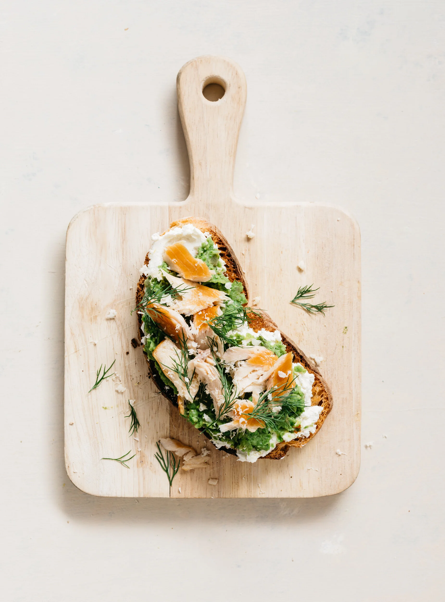 Smashed Peas on Toast with Goat Cheese, Fresh Horseradish, Herbs and Smoked Trout