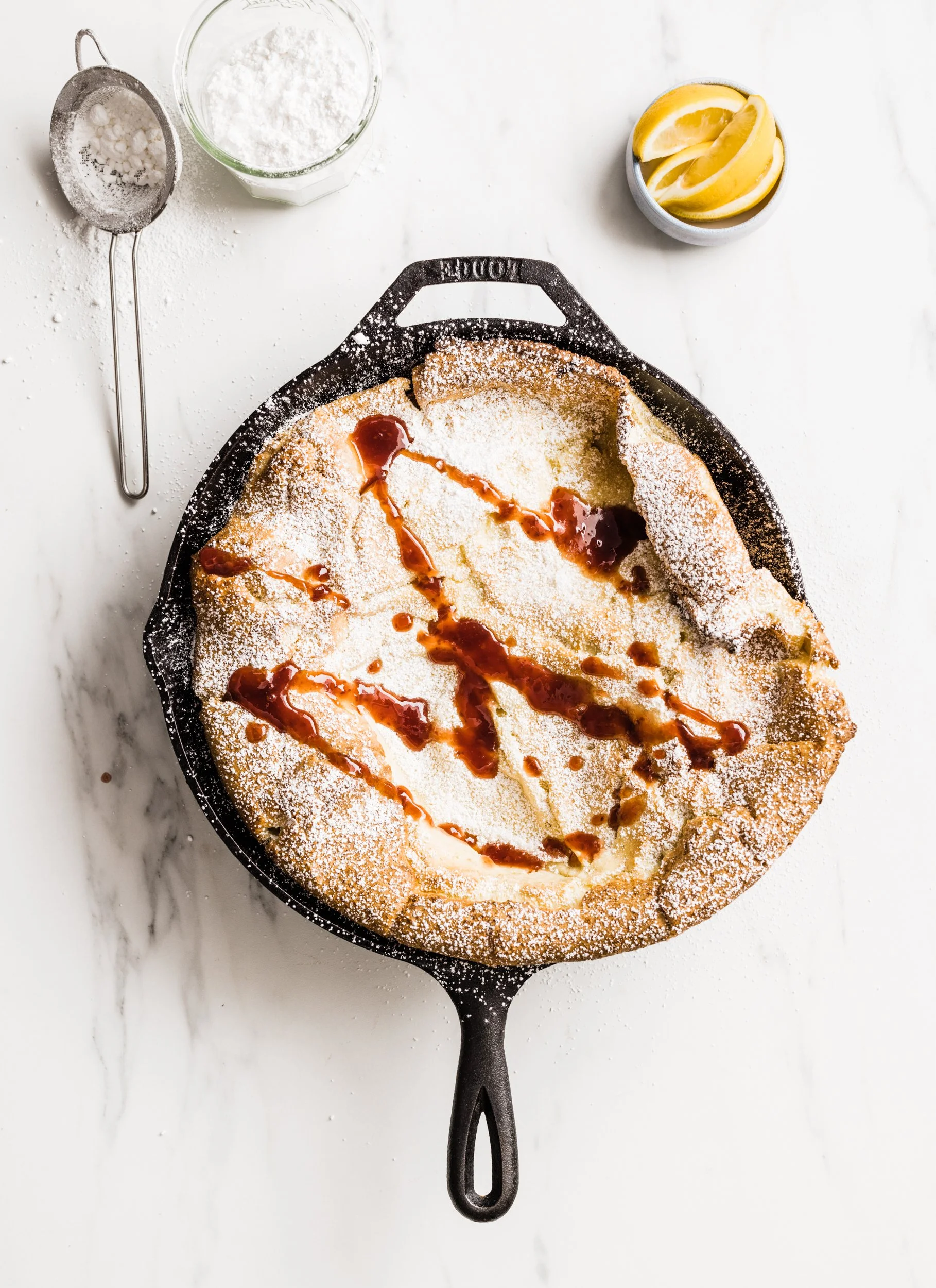 Simple Dutch Baby with Lemon, Powdered Sugar and Berry Jam