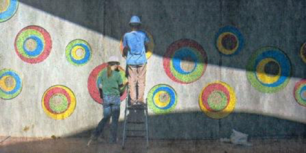 Zarah Daniels left and Nate Murano work on a mosaic installation at the new Kansas Humane Society building near K-96 and Hillside. Wichita artist Tina Murano created the artwork.