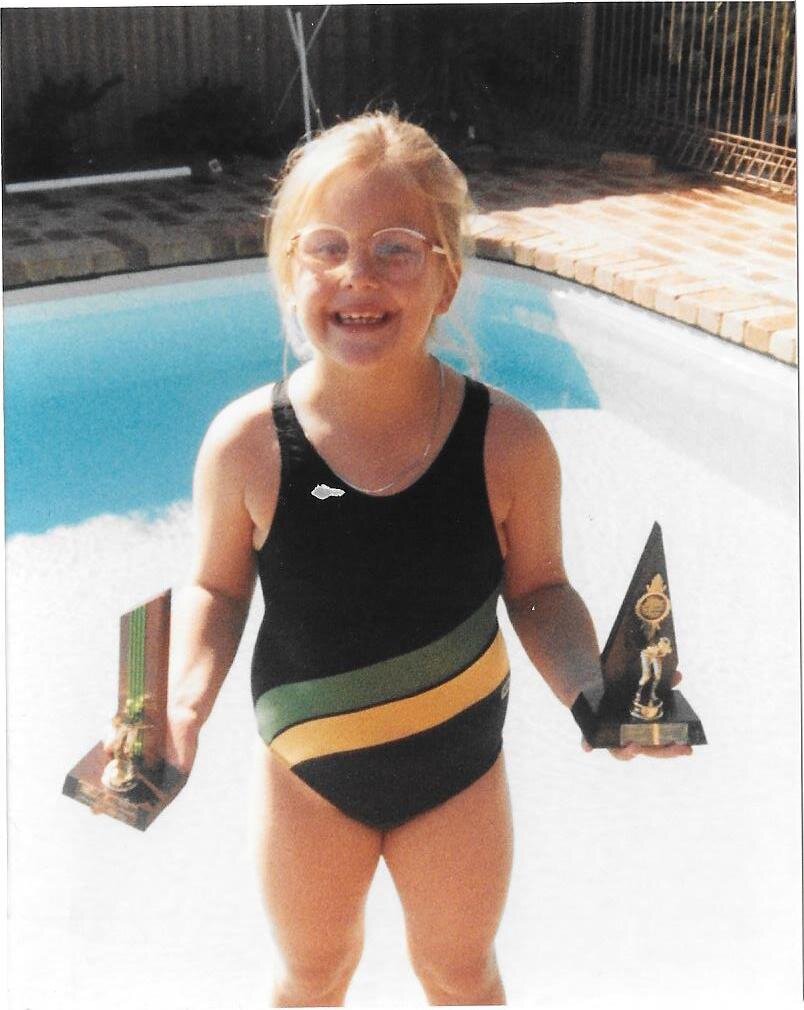 Jen with swim trophies Aged 7.jpg