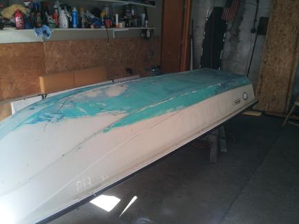 With the boat flipped over and before sanding.