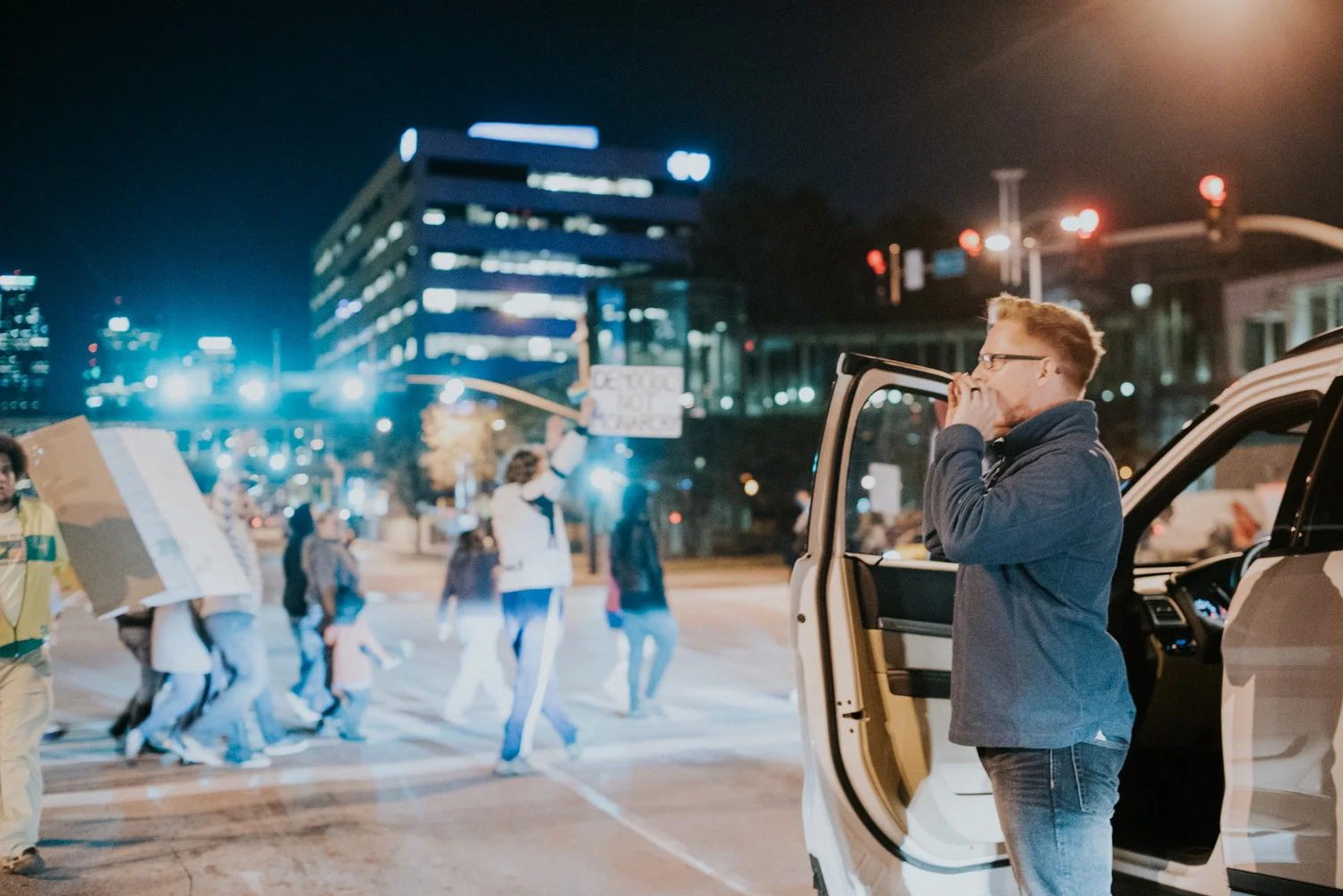  A man hops out of his car in support for the Love Trumps Hate protesters as they cross an intersection in downtown Kansas City.