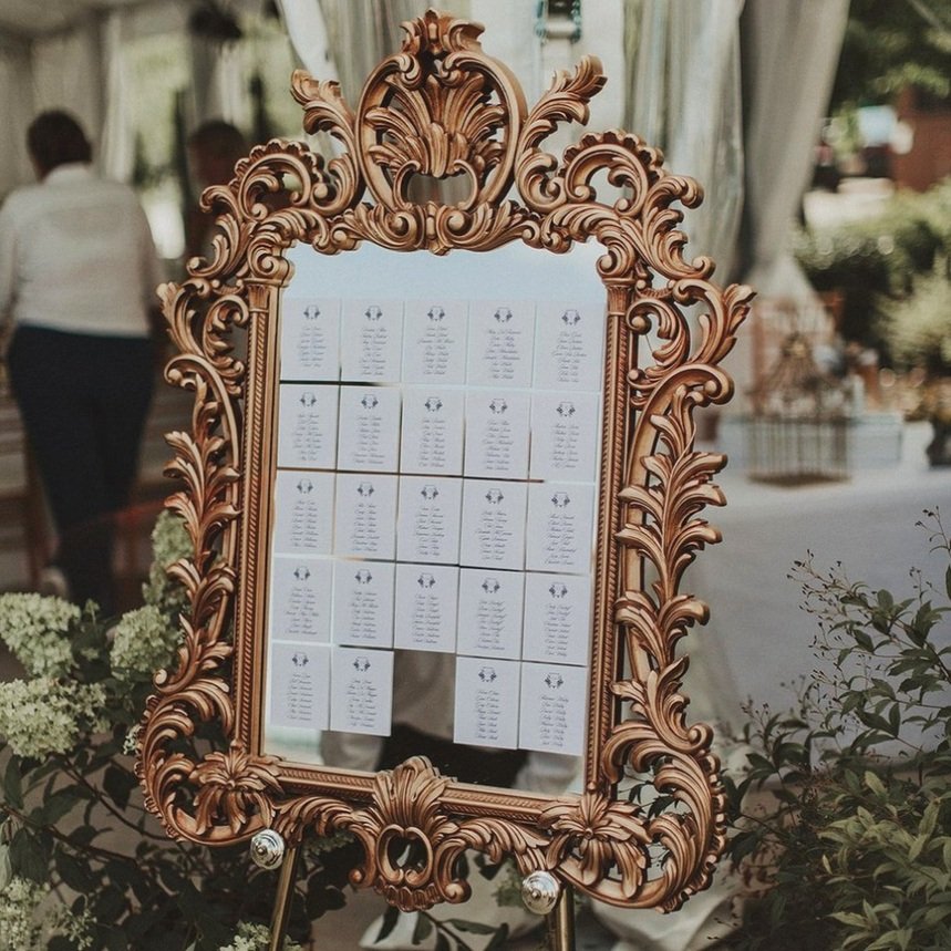 Our ornate gold mirror with white calligraphy on gold easel with a floral  garland, in the tre…