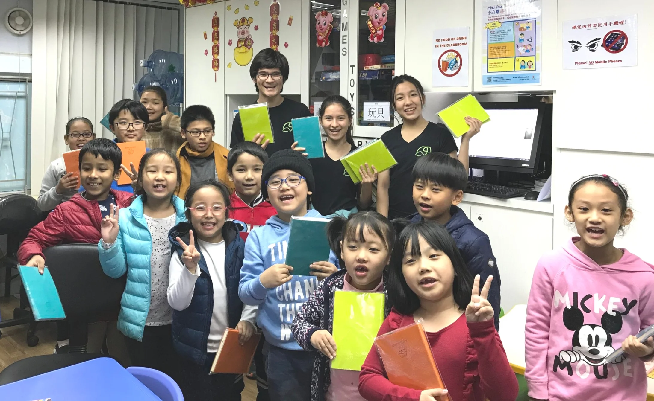 Shimmers assisting Lumivoce handing out wildlife story notebooks as a gift to underserved ethnic minority children in hong kong.