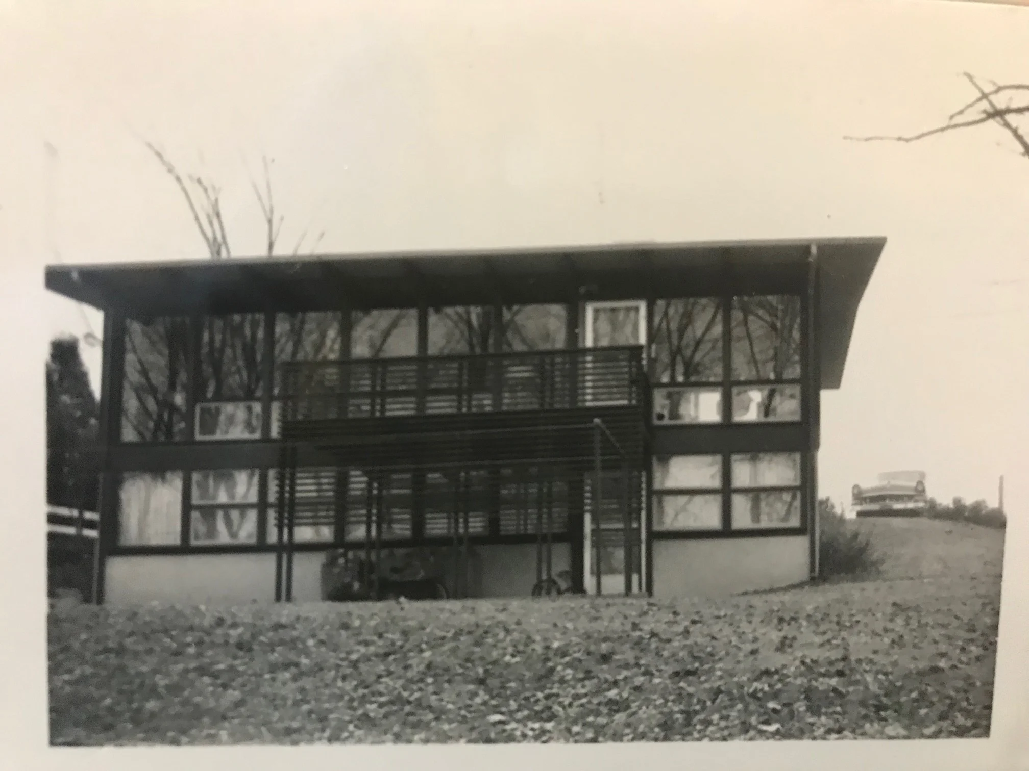 EARLY PHOTO OF TWO STORY WINDOW WALL AND BALCONY