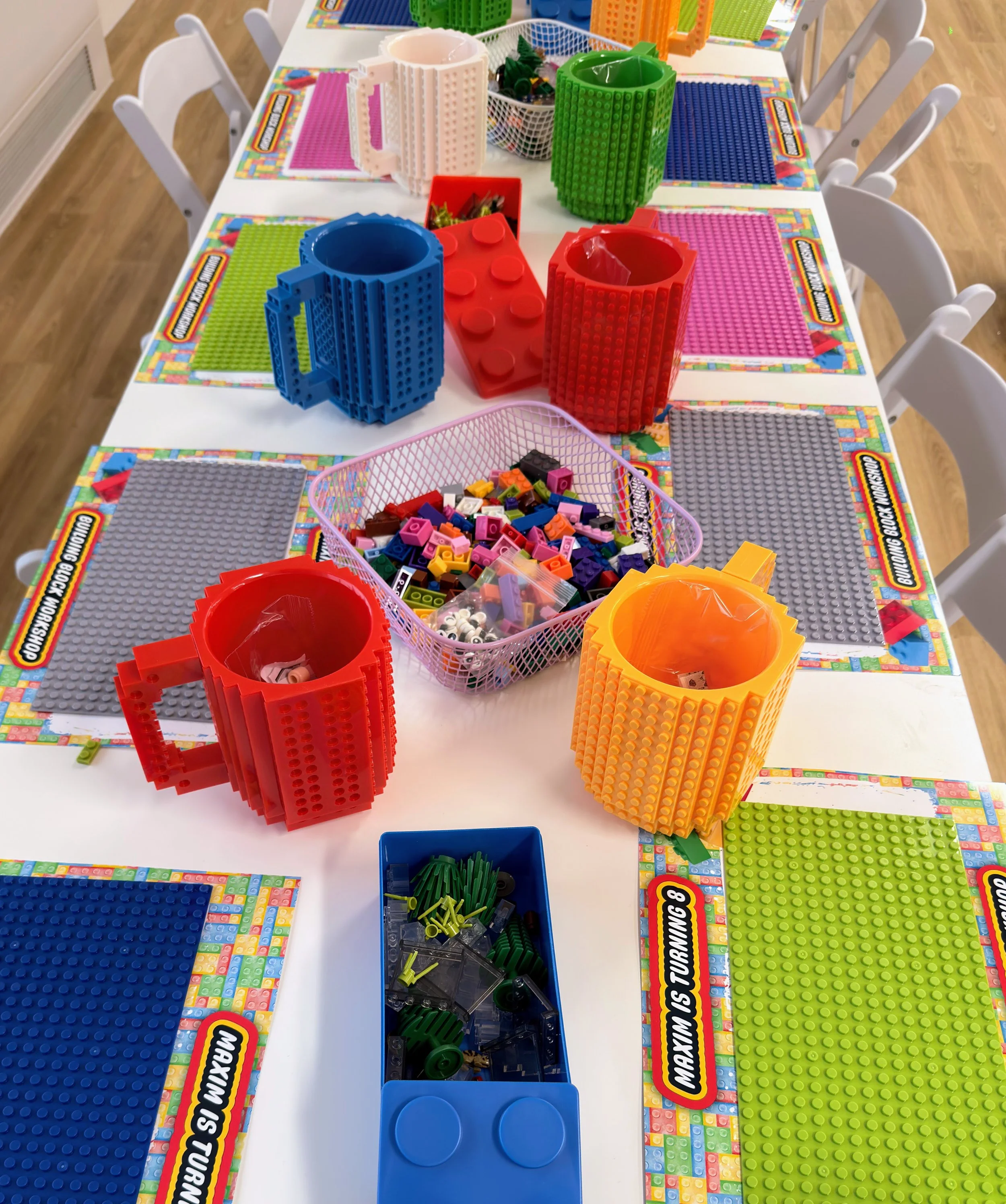 Brick Master LEGO building table for kids’ parties and workshops, featuring colorful LEGO baseplates, oversized LEGO-style brick cups, and bins of assorted LEGO bricks for creative play, STEM learning, birthday parties, and group building activities.