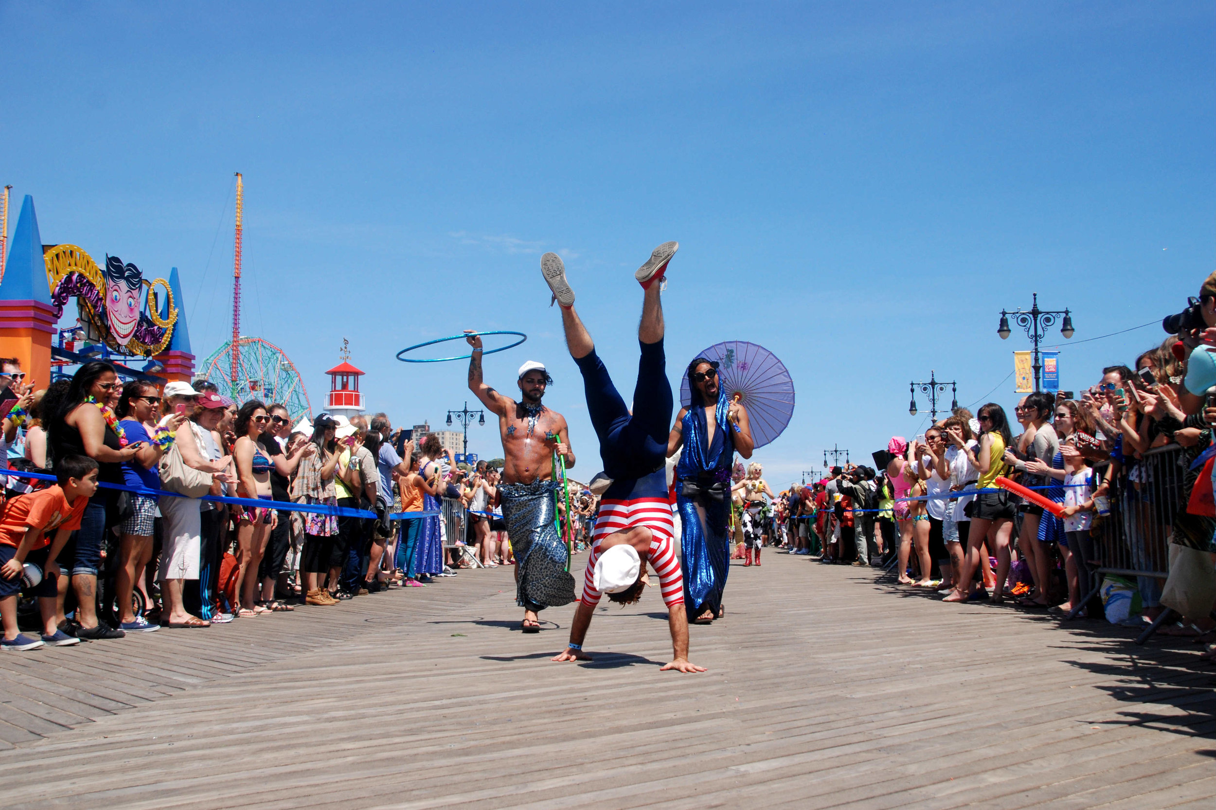  A man does a handstand on the Coney Island boardwalk at the annual Mermaid Parade on June 21, 2014.    