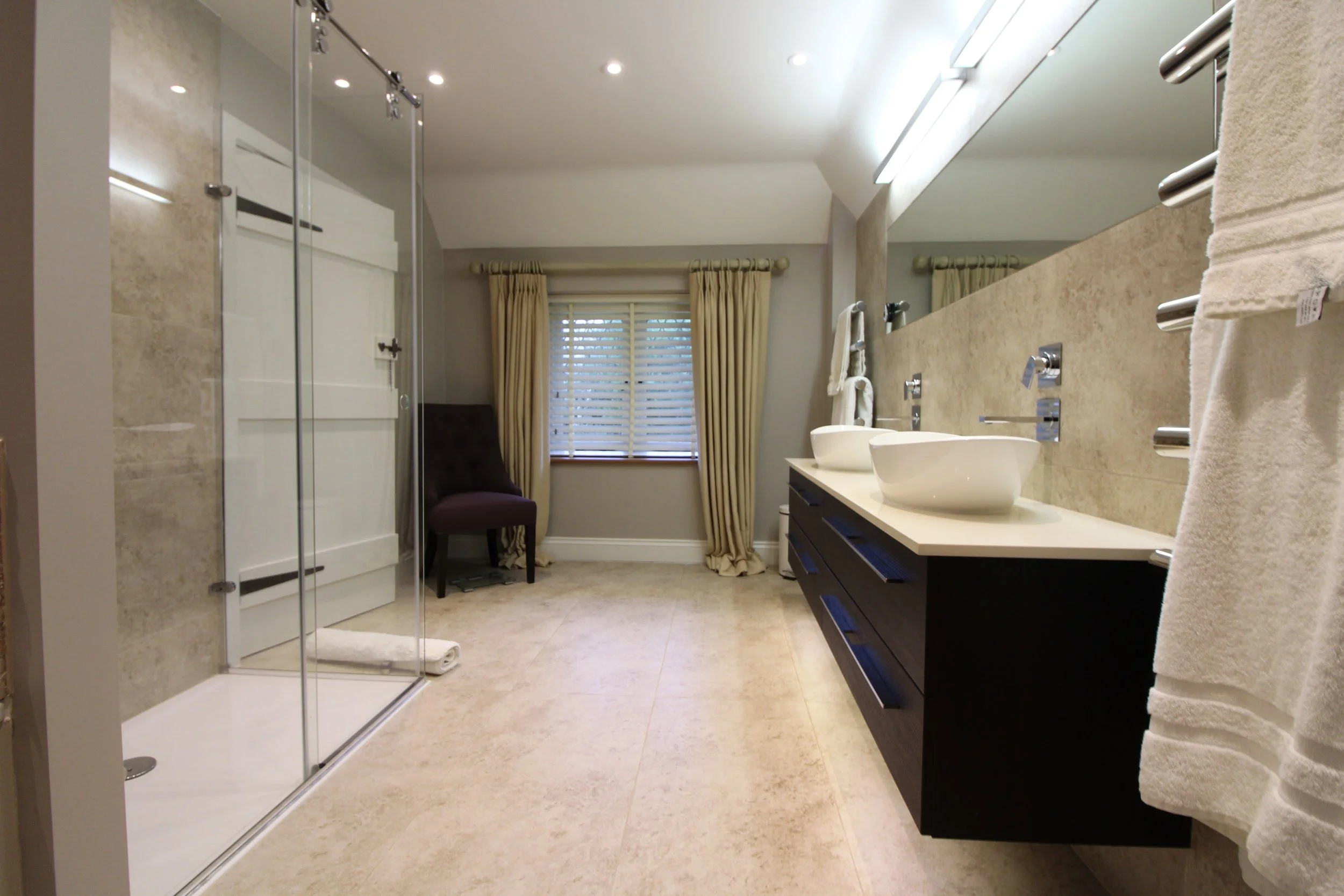 Stunning shower room, with porcelain tiles. Featuring a wall-hung double basin unit and wall mounted taps. 