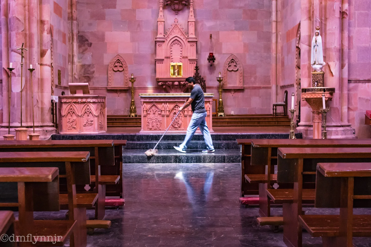 A caretaker sweeps in front of the altar of Iglesia Fátima in Zacatecas.