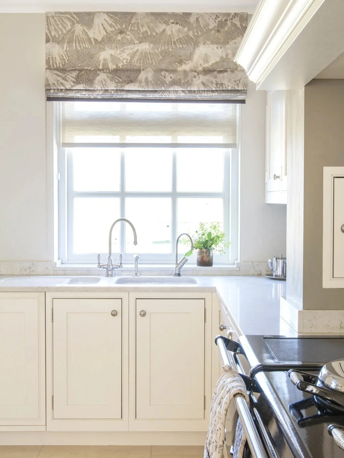 Bright and airy shaker kitchen with marble countertop and AGA stove.4