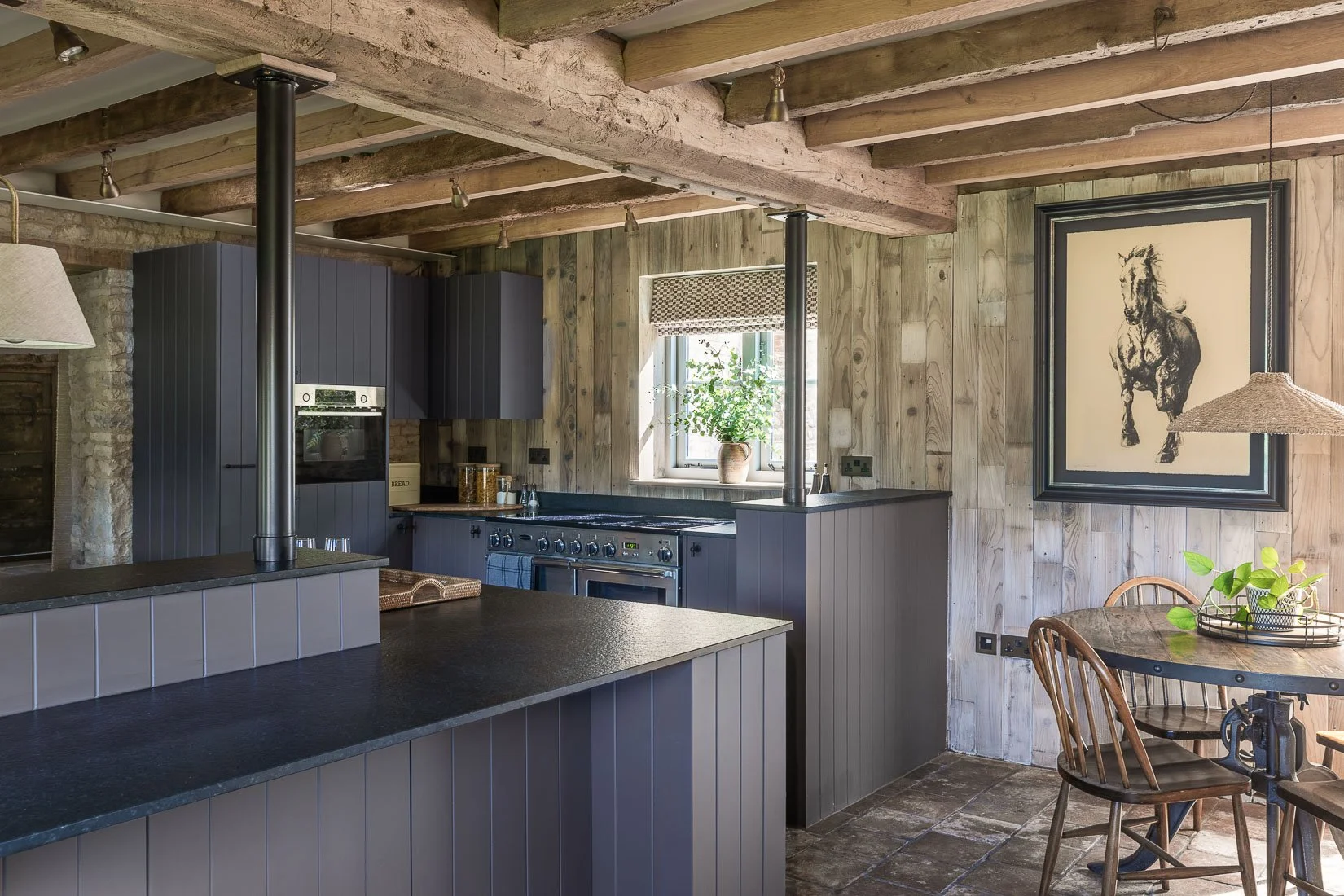 Period coach house outbuilding conversion restoration tongue and groove kitchen diner with wall panelling and horse artwork.