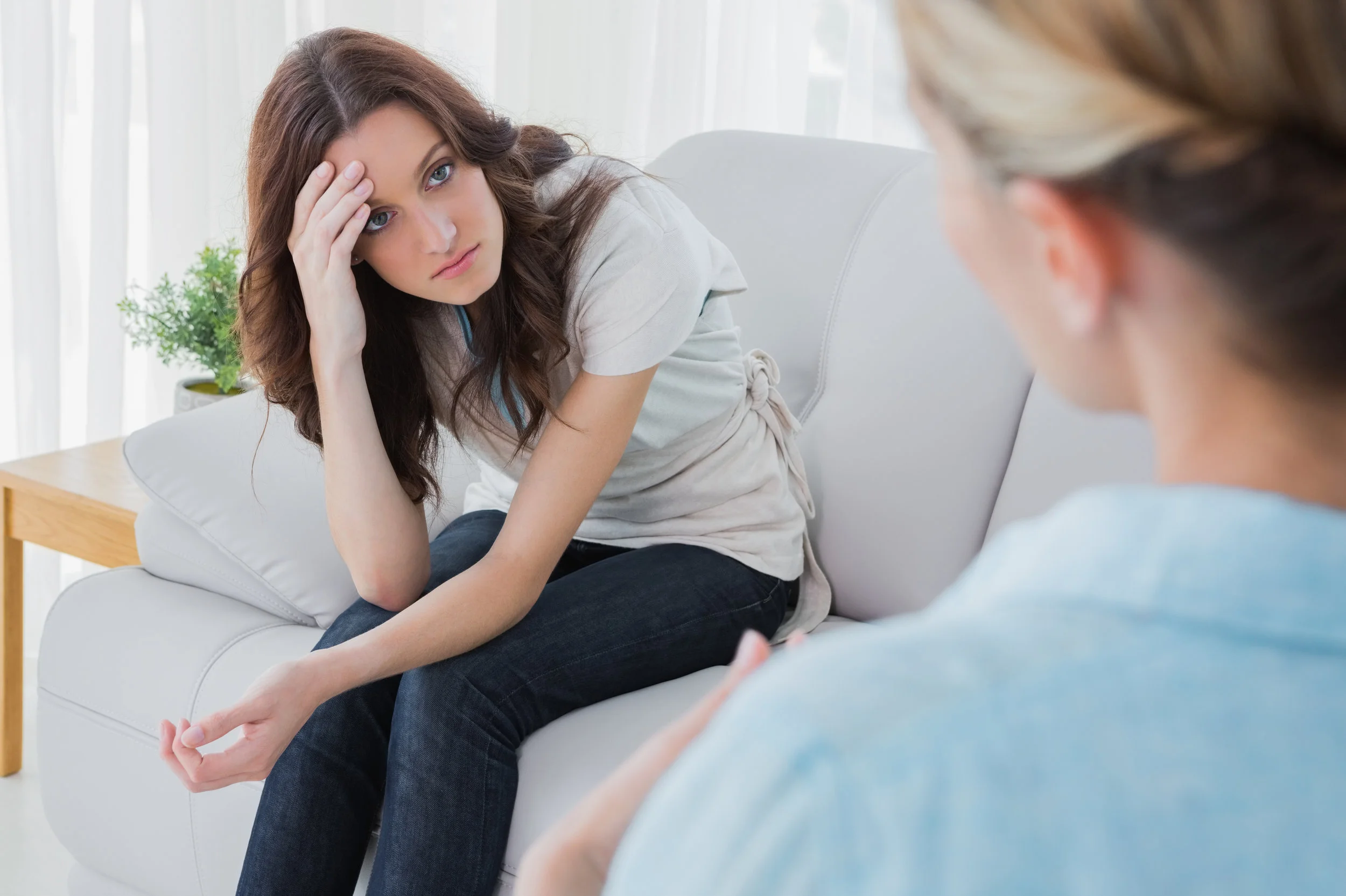 Worried woman sitting and looking at her therapist.jpg