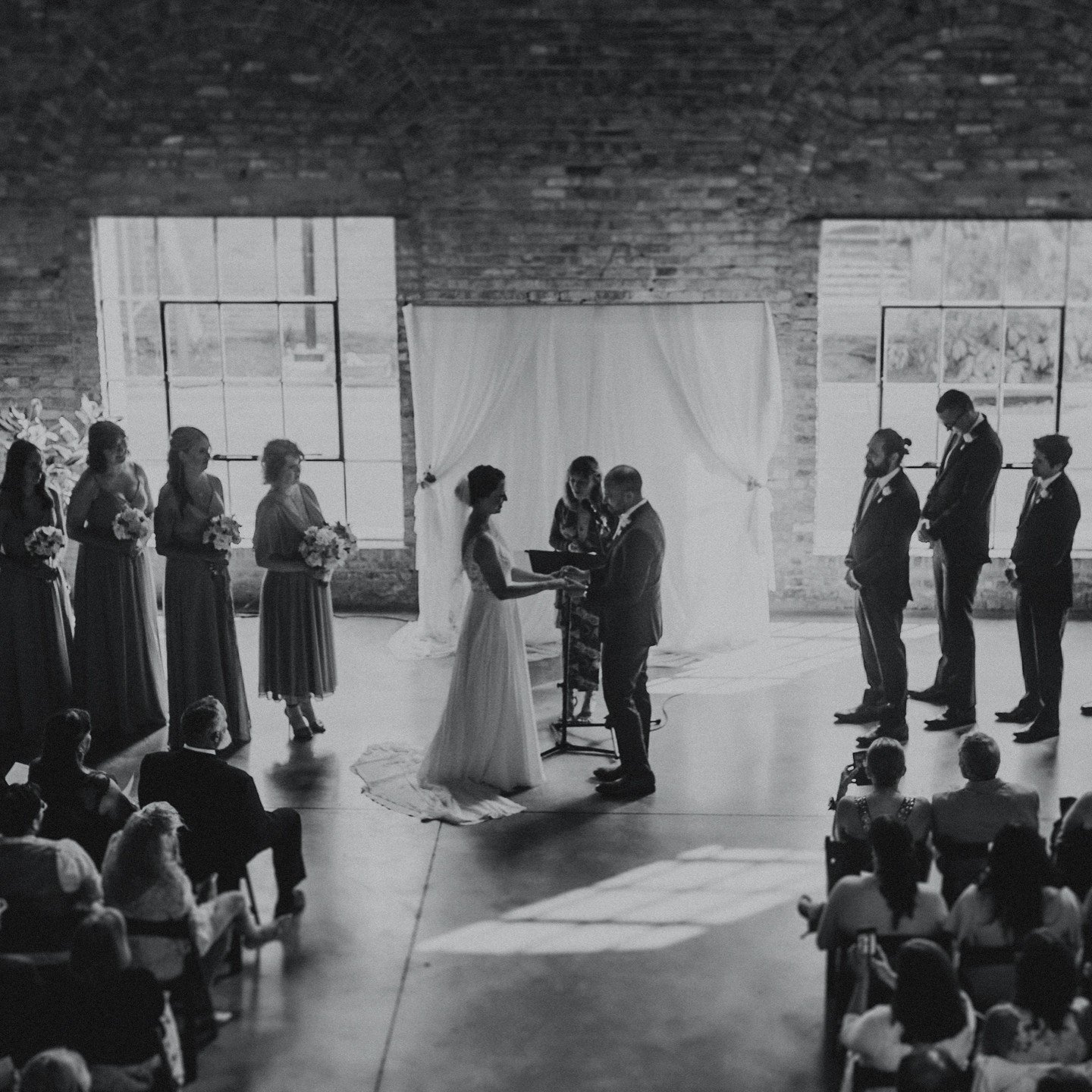 @garverfeedmill was the perfect setting for Emily + Patrick's wedding, and I cannot wait for our weddings there this year!!! 😻
.
.
.
.
.
[Image Description: A black &amp; white image of a wedding ceremony. The photo is being taken from a balcony and