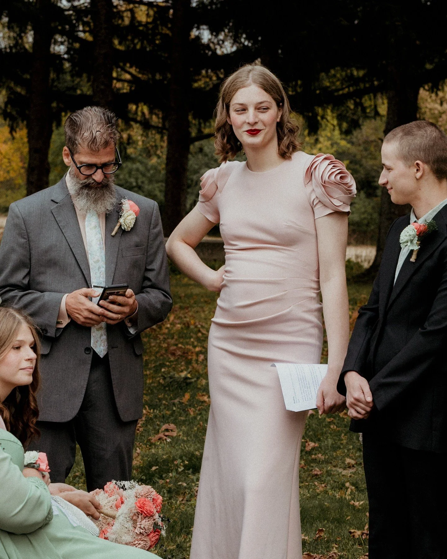 Some of the coolest guests to ever grace a wedding 🤩 I LOVE these looks and those colors! 
.
.
.
.
.
.
[Image Description: A group of people dressed respectively in a grey suit, blush colored gown with blossoms on the shoulders, and a charcoal grey 