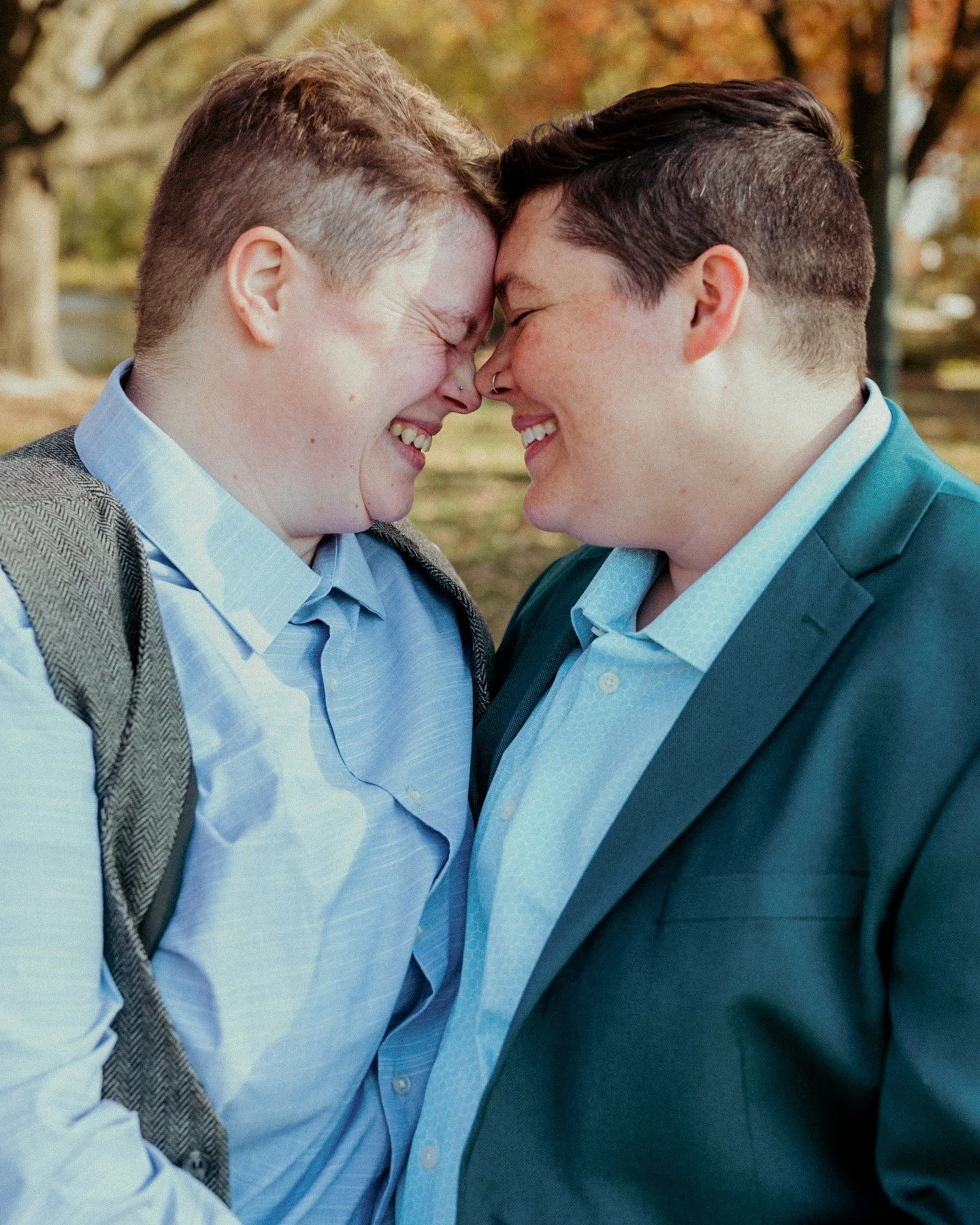 Happy anniversary to Rae + Jesii! 🎉💖
.
.
.
.
.
[Image Description: A white non-binary person with short blonde hair, wearing a light blue button-up dress shirt and grey wool vest, is leaning their head into another white non-binary person who has s