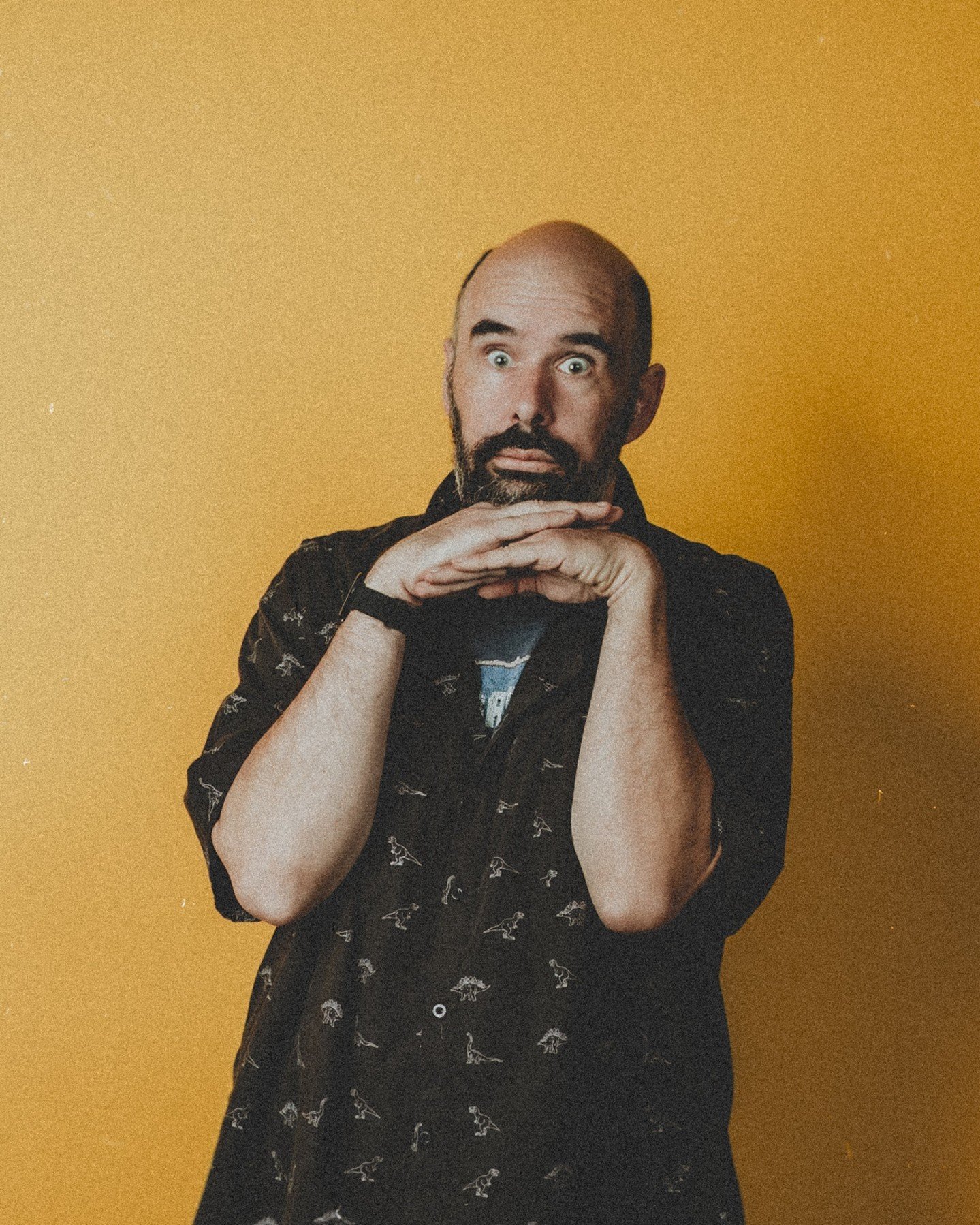 A little lighting test action from just before last years' Quad Squad team portraits! 
.
.
.
.
.
.
[Image Description: Rob, a white man with a shaved head and black &amp; grey beard, is wearing a short-sleeved button up dark shirt with dinosaur skele