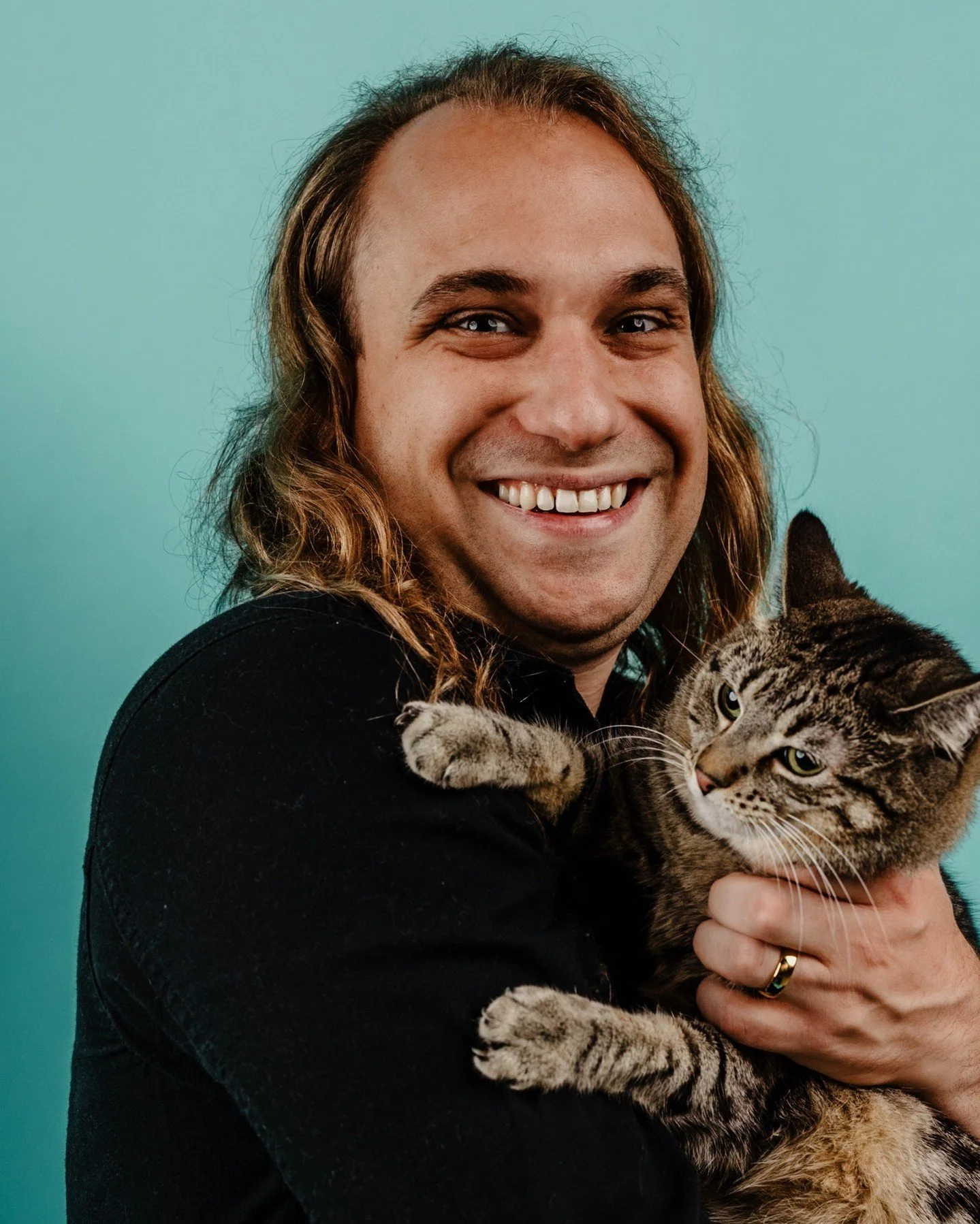 Who says you can't bring your cat to be in your headshots with you? No one I want to be friends with, that's for sure 😻
.
.
.
.
.
.
[Image Description: A white non-binary person with long light brown hair wearing a black shirt is smiling broadly and
