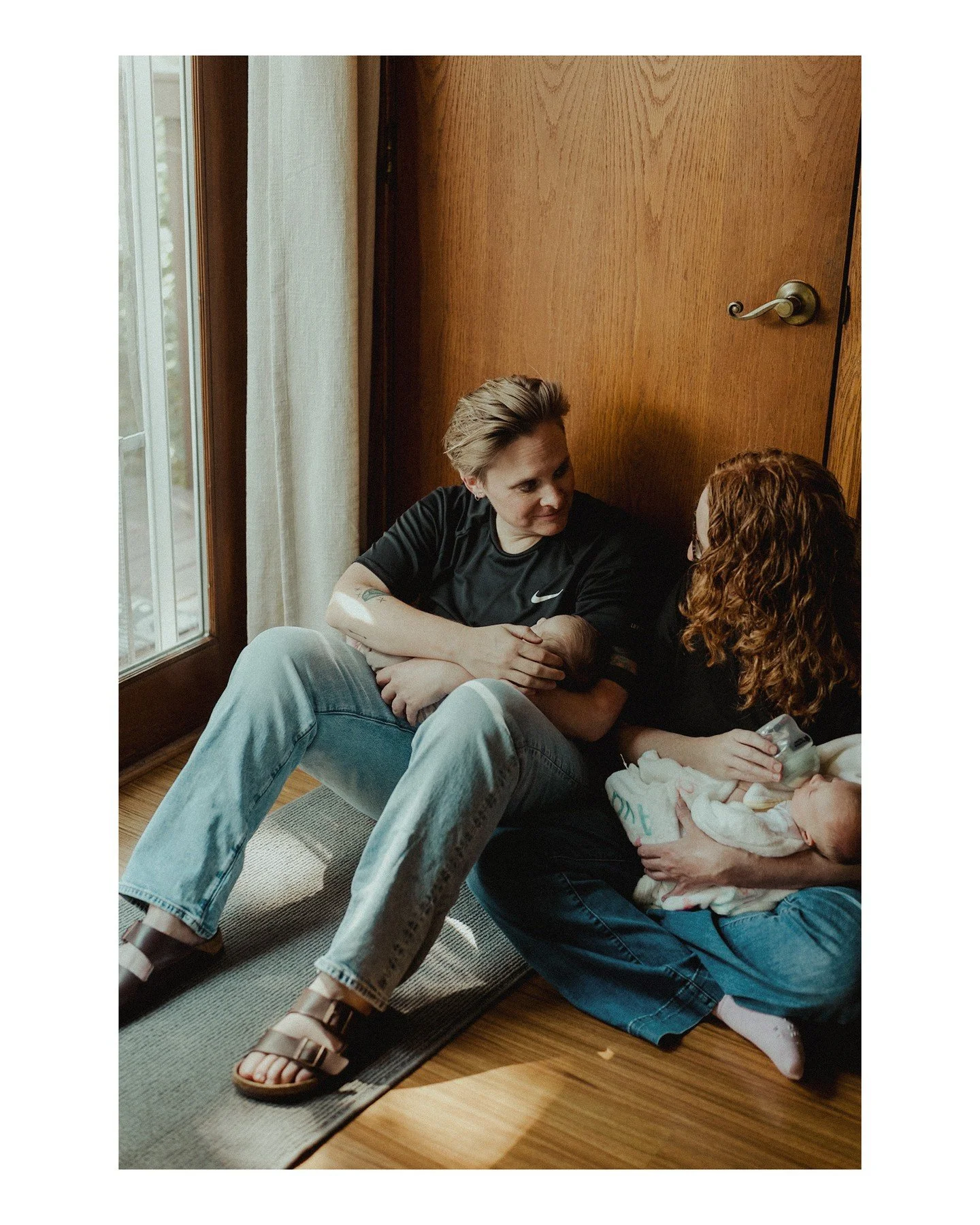 I adore this image of Anne + Amy cradling Ava + Ali (or The A Team as they're known colloquially). At home, lifestyle newborn portraits are the best! 😍
.
.
.
.
.
.
[Image Description:  A white person with short blonde hair, a black t-shirt, and ligh