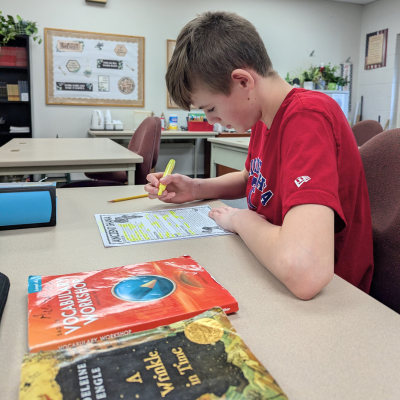 GCS boy doing worksheet at desk.png