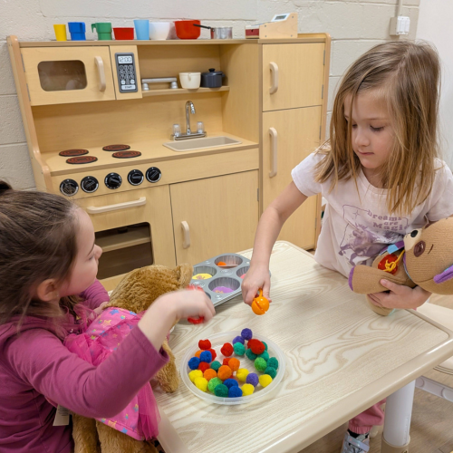 two pre-k students doing a play learning activity