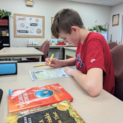 Student reading worksheet at desk