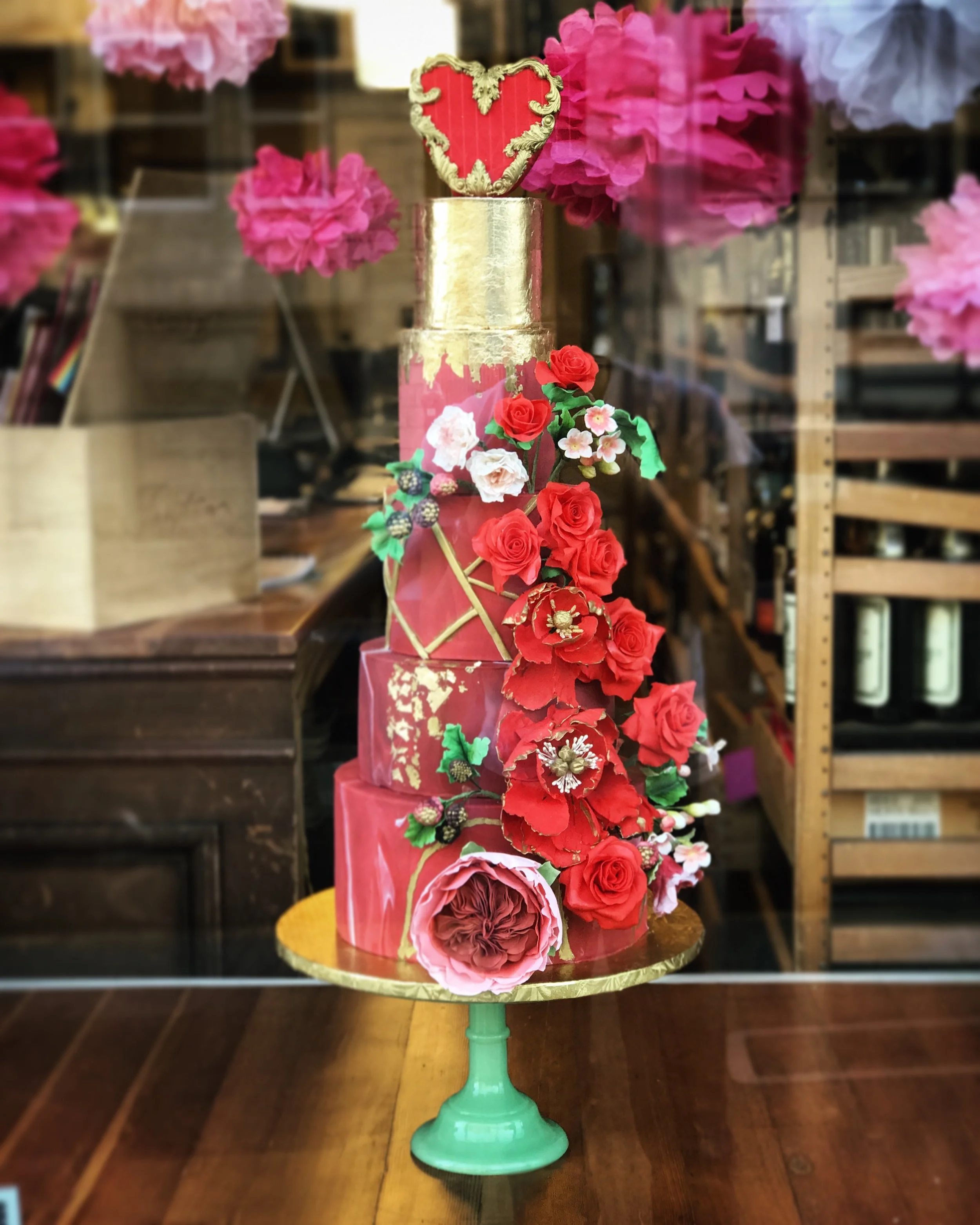 Marble red fondant cake with sugar paste roses and gold accents and edible heart topper 