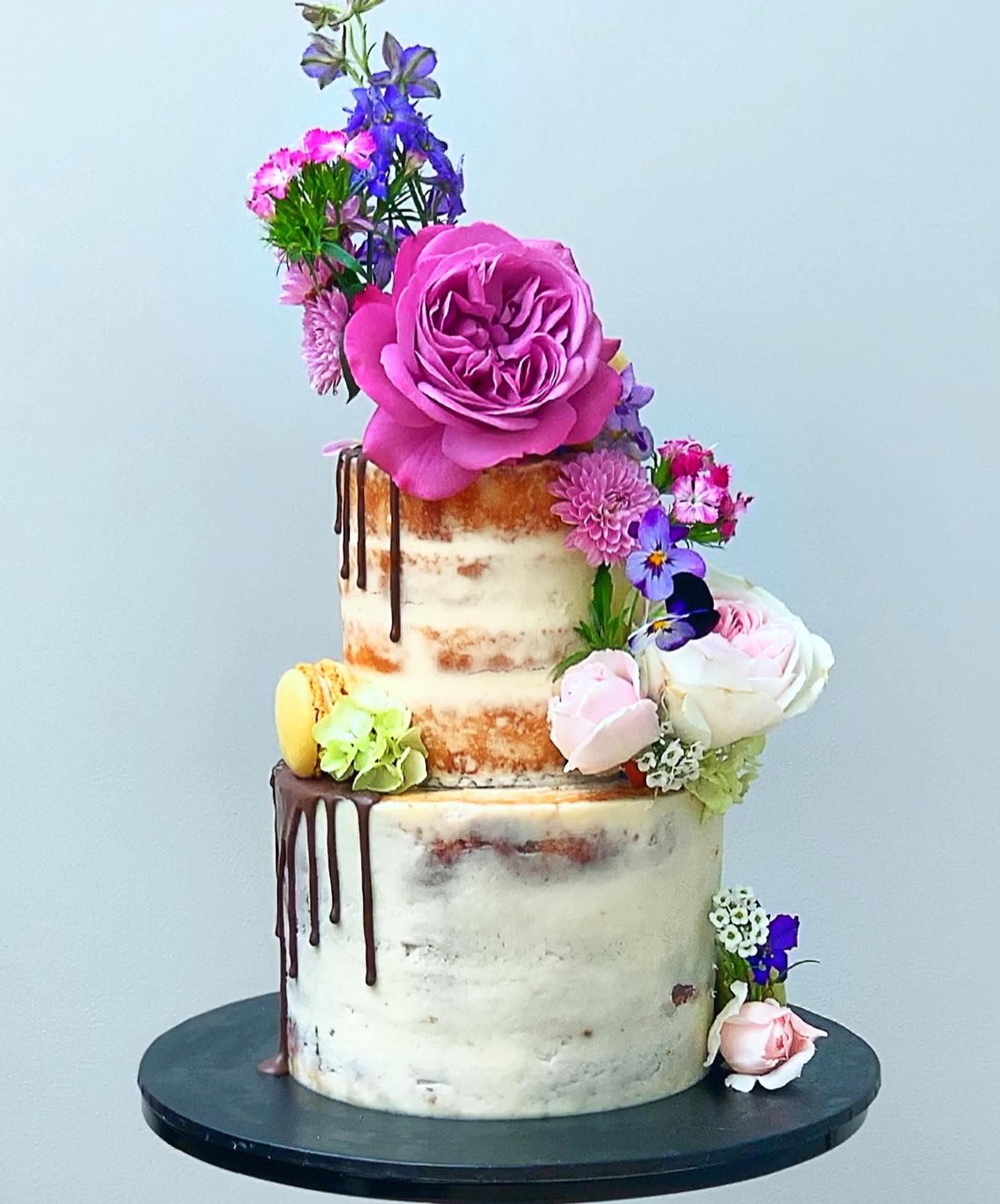 Semi naked wedding cake with chocolate drips and fresh florals