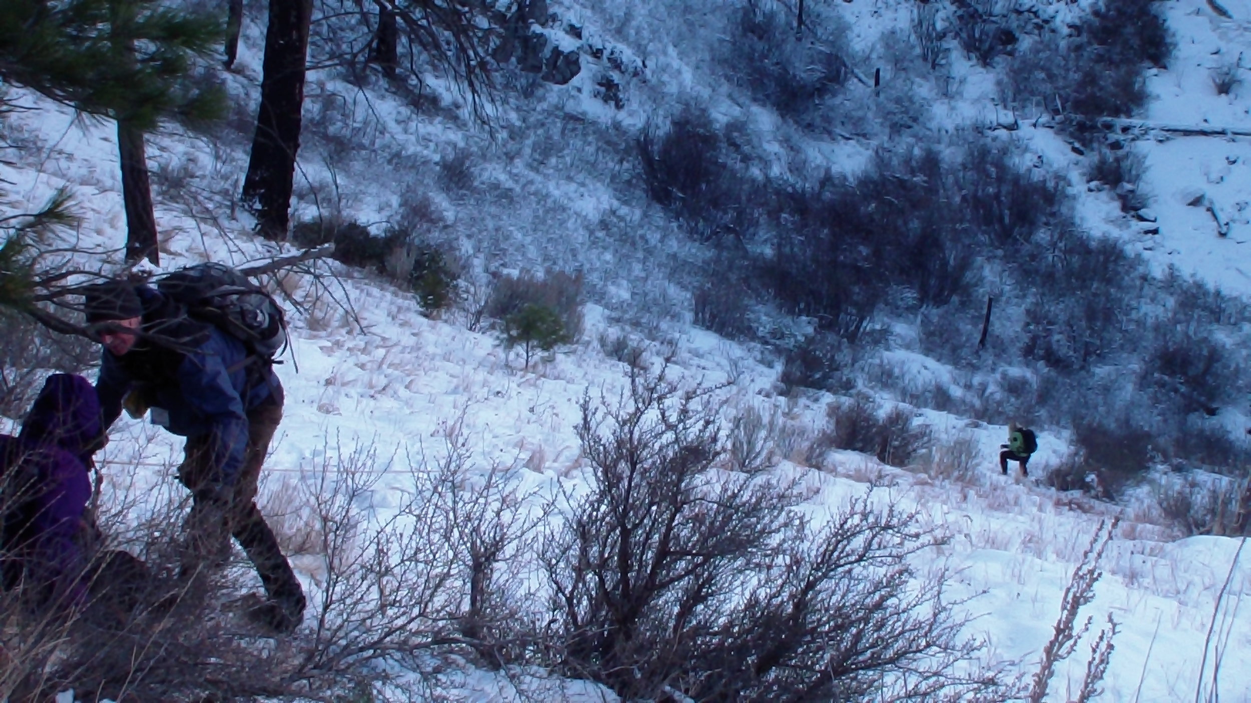 A steep, snowy descent is best negotiated with the aid of a hand line.