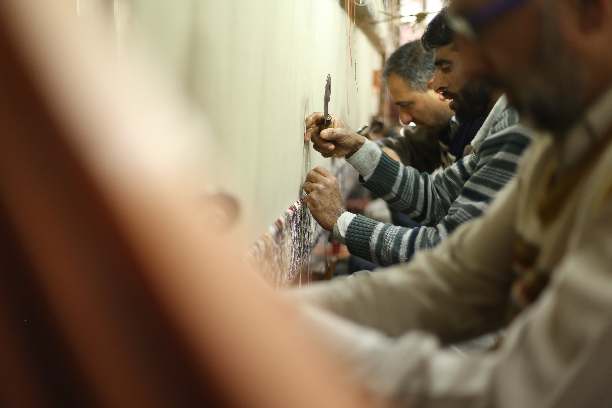 A group of weavers at the loom, together