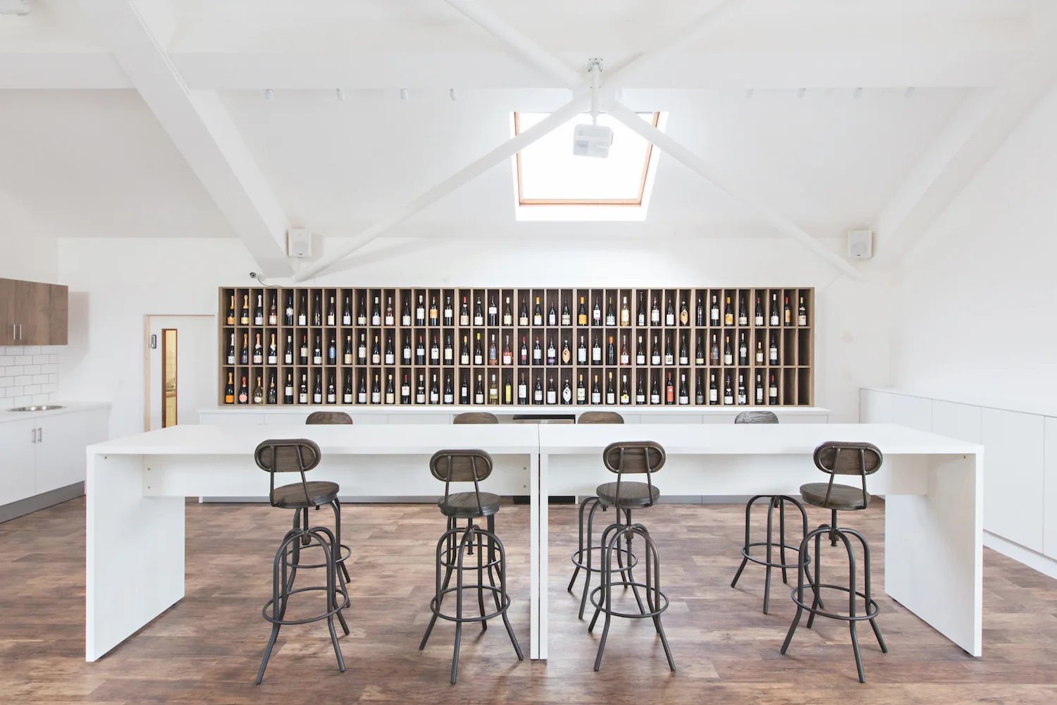 London tasting room with wine display, high level benches and fitted storage cupboards.