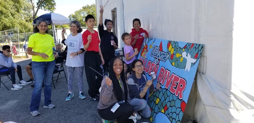  Community members and youth participating in the painting process onsite at the river.  Photo credit: Sifu Mai Du 