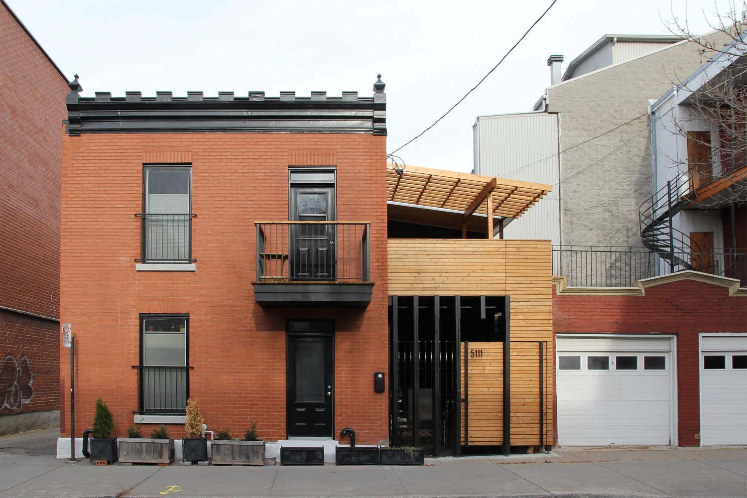 Clôture d’intimité sur le Plateau Mont-royal. Fabrication en bois naturel et bois noir. Pergola à l’étage.