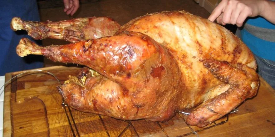 Cooked turkey and ready to be carved (looks like one of the kids wanted to touch it to check for tenderness :D )