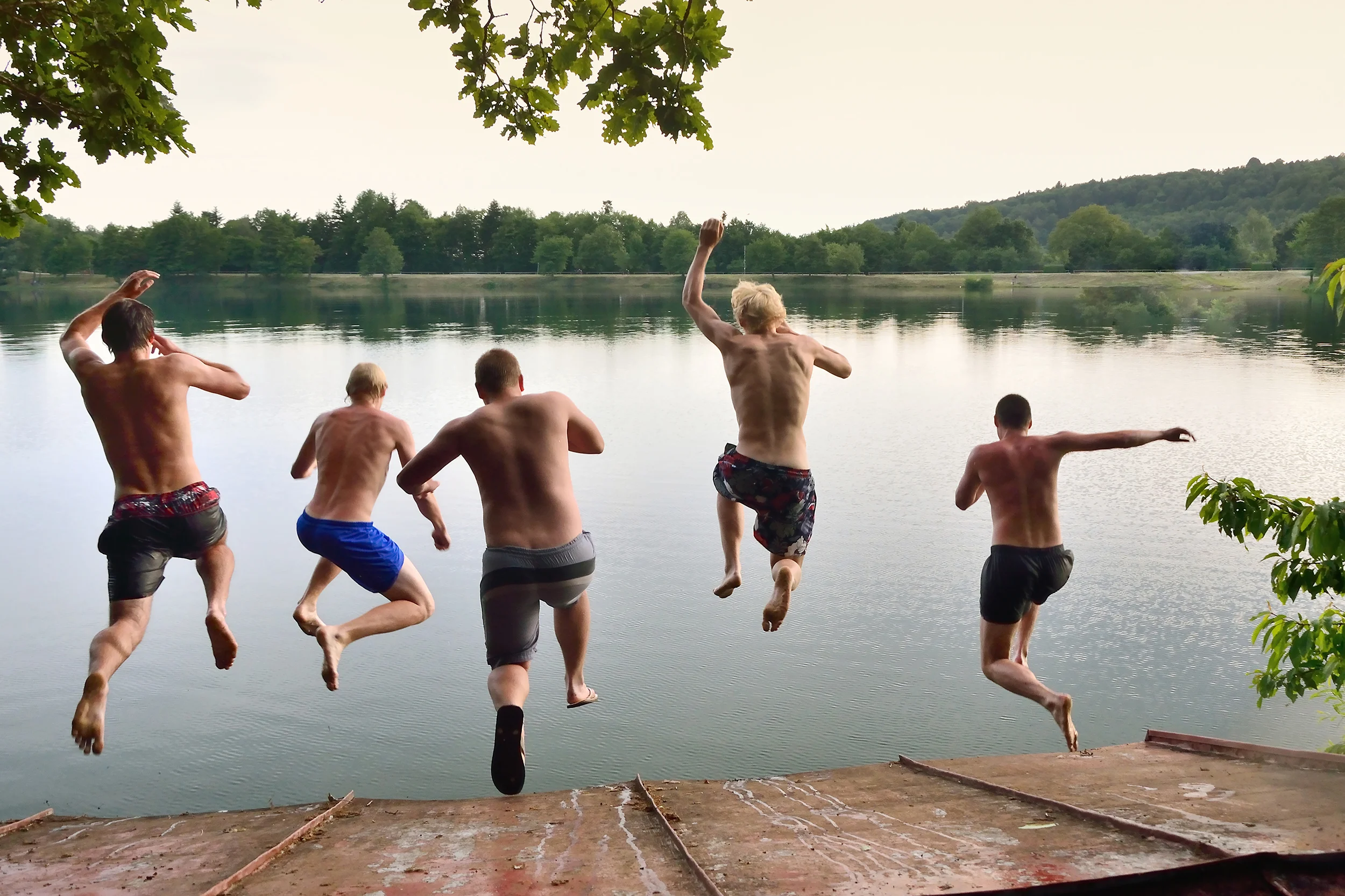 Boys jumping into lake at Church activity