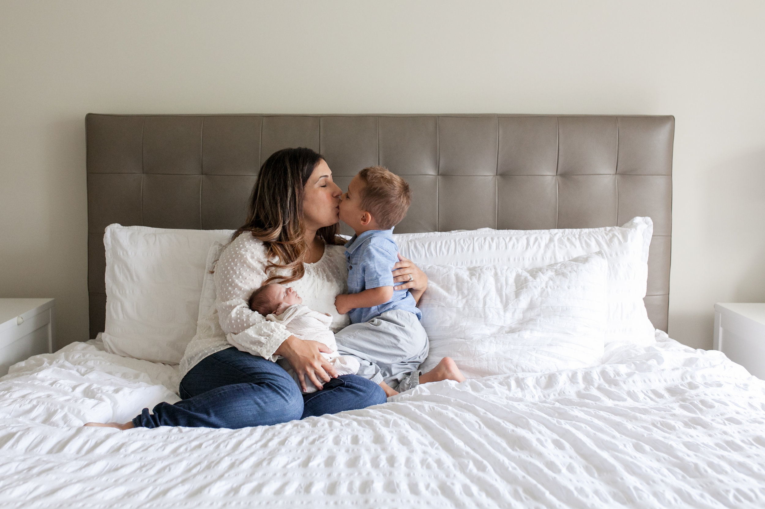 mom and children on bed - rochester michigan in-home family photographer