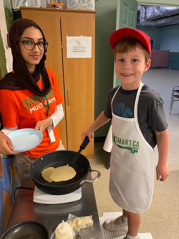Child stirring bowl at camp