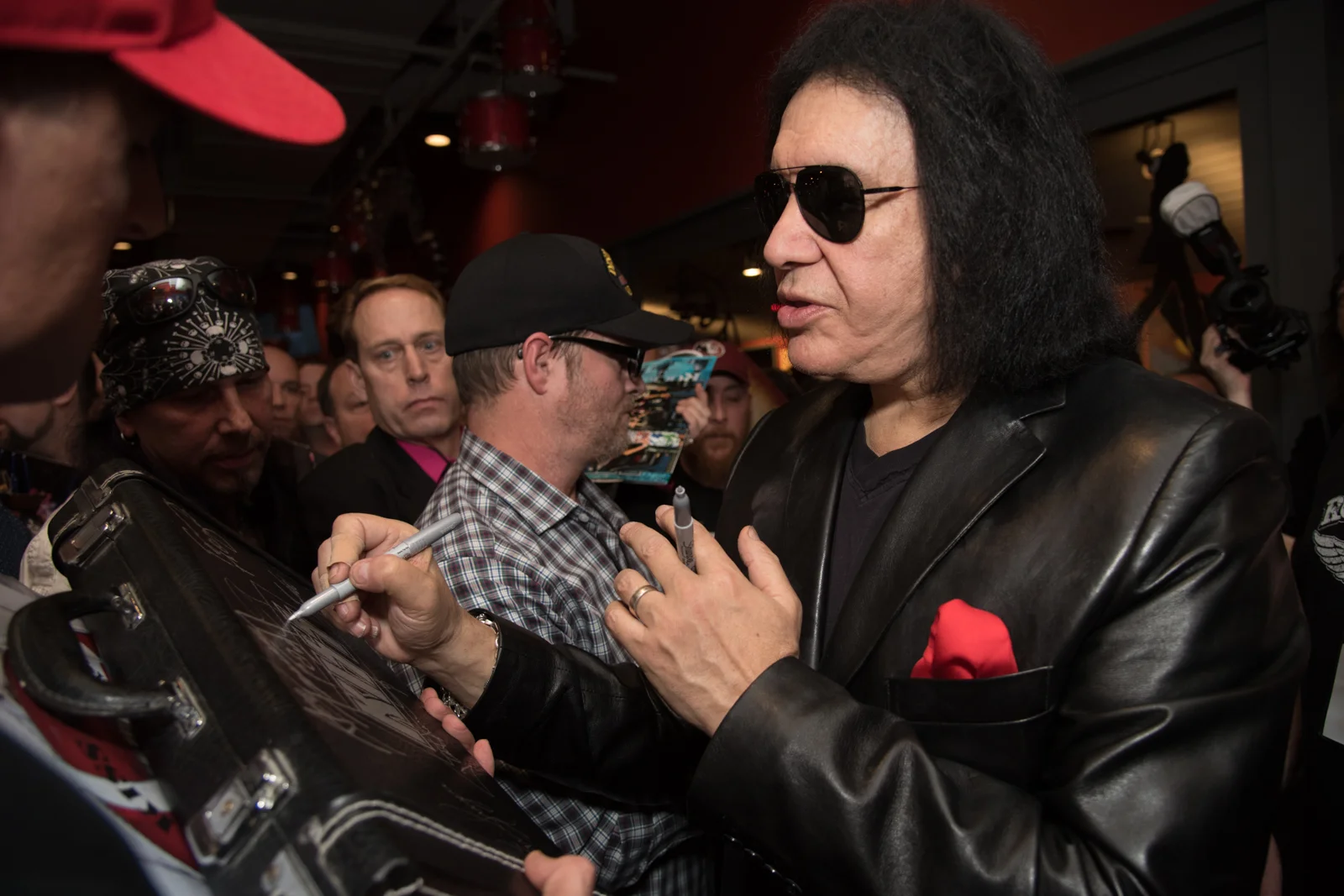 Gene Simmons of KISS signs autographs for fans at the grand opening of Rock & Brews in Chesterfield, Mo.