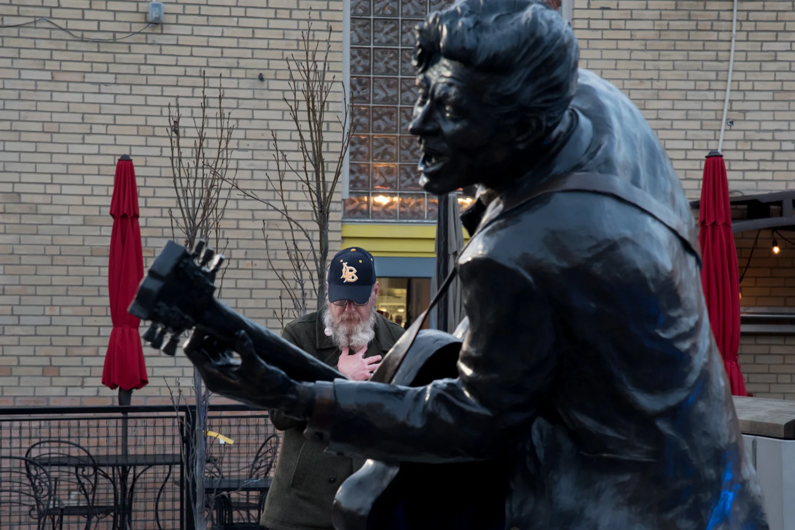 A mourner stops to pay respects to the late Chuck Berry at a statue of the Rock and Roll Hall of Fame member in the Delmar Loop of University City, Mo.